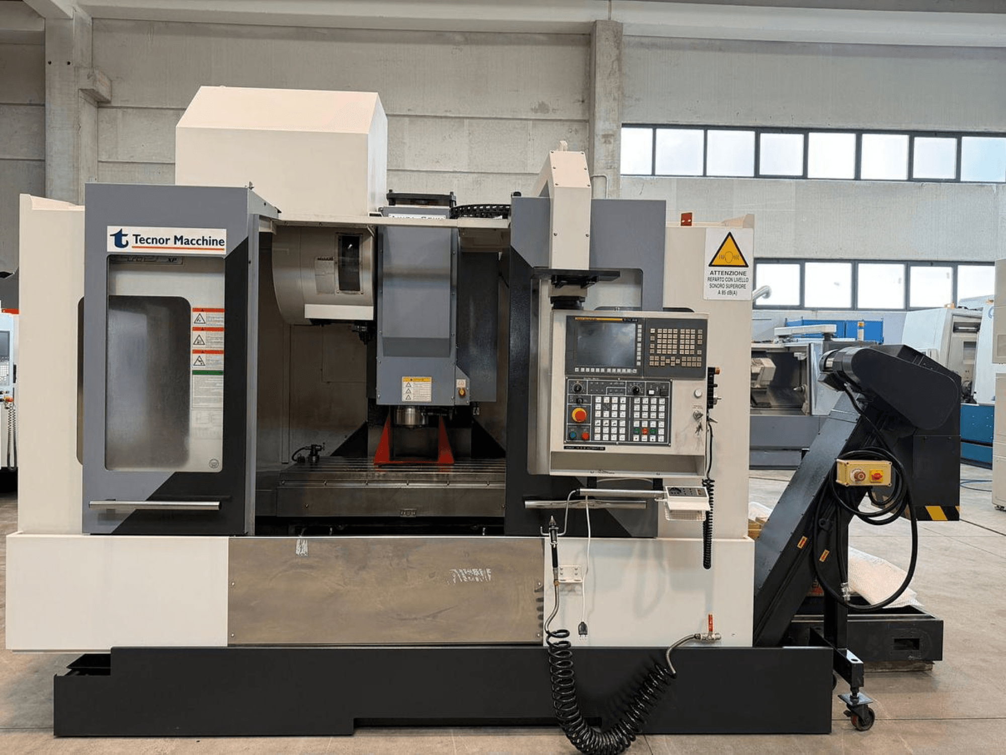 Tecnor Machine CNC-Fräsmaschine, Vorderansicht, mit Bedienfeld mit Tasten, Warnschildern und Werkzeughalter.