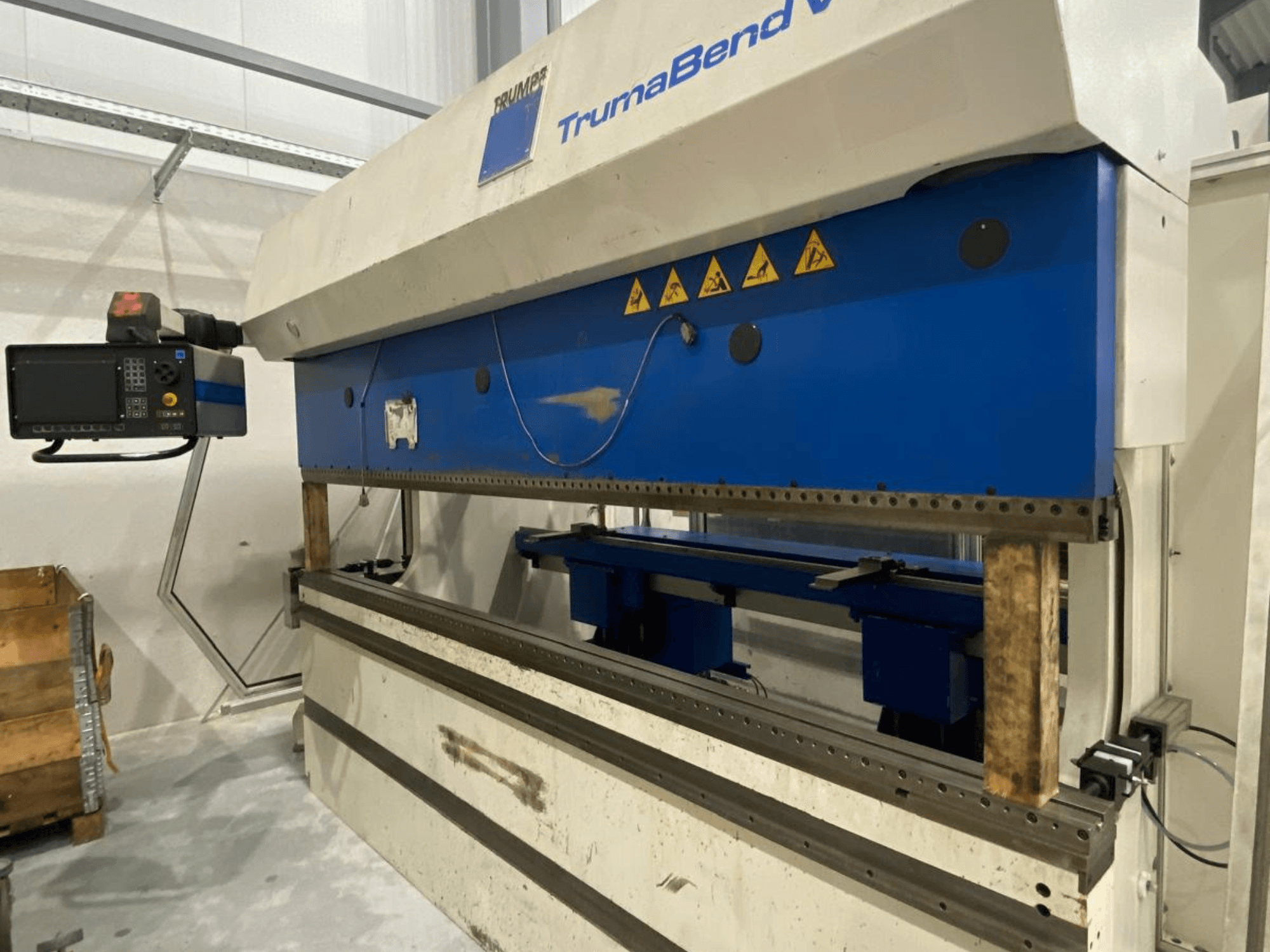 TRUMPF Trumabend V130 Abkantpresse, Vorderansicht, mit Bedienfeld, blauen Elementen und sichtbaren Sicherheitshinweisen.