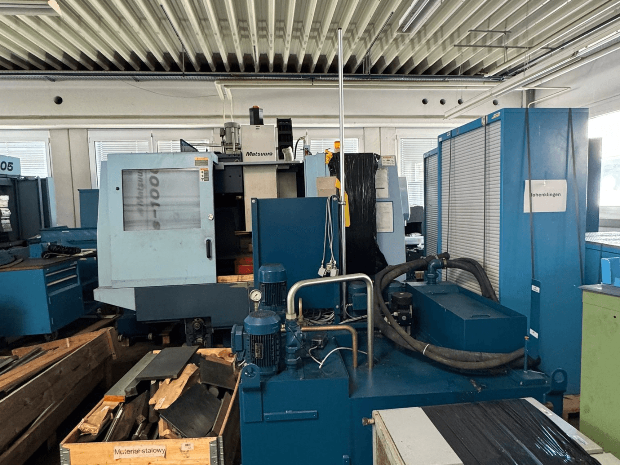 Vorderansicht des vertikalen Bearbeitungszentrums Matsuura Vplus 1000/40 mit Darstellung der Steuerung, der Motoren und der umgebenden Werkstattumgebung.