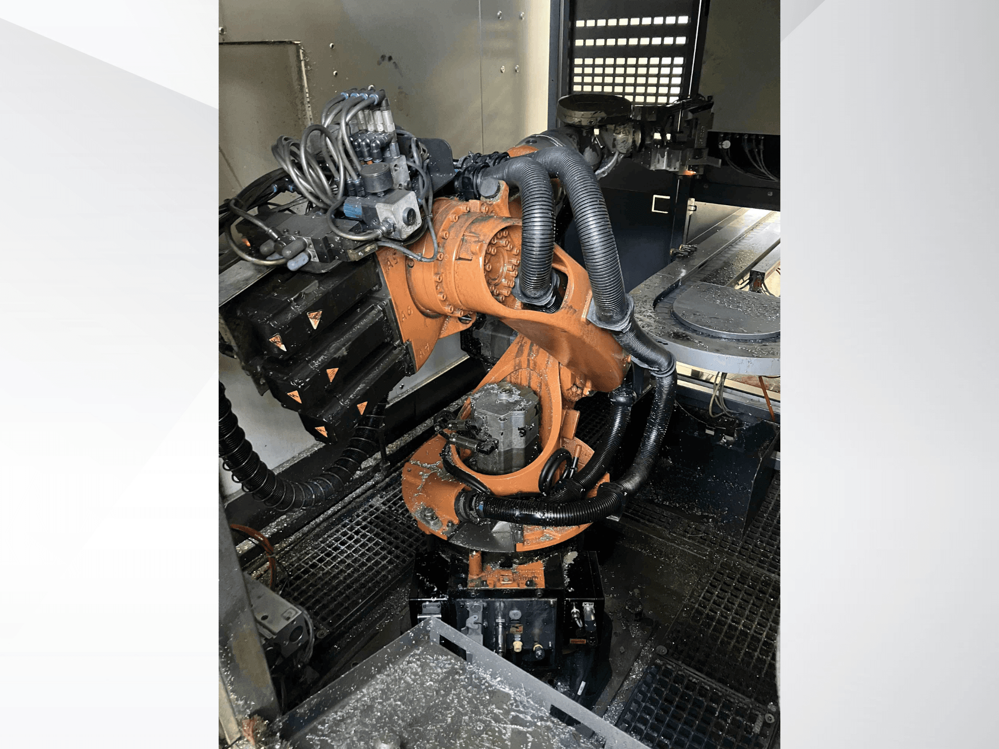 KUKA KR 16-Roboterarm in der Draufsicht, der die mechanischen Komponenten und die Verkabelung in einer Werkstattumgebung zeigt.