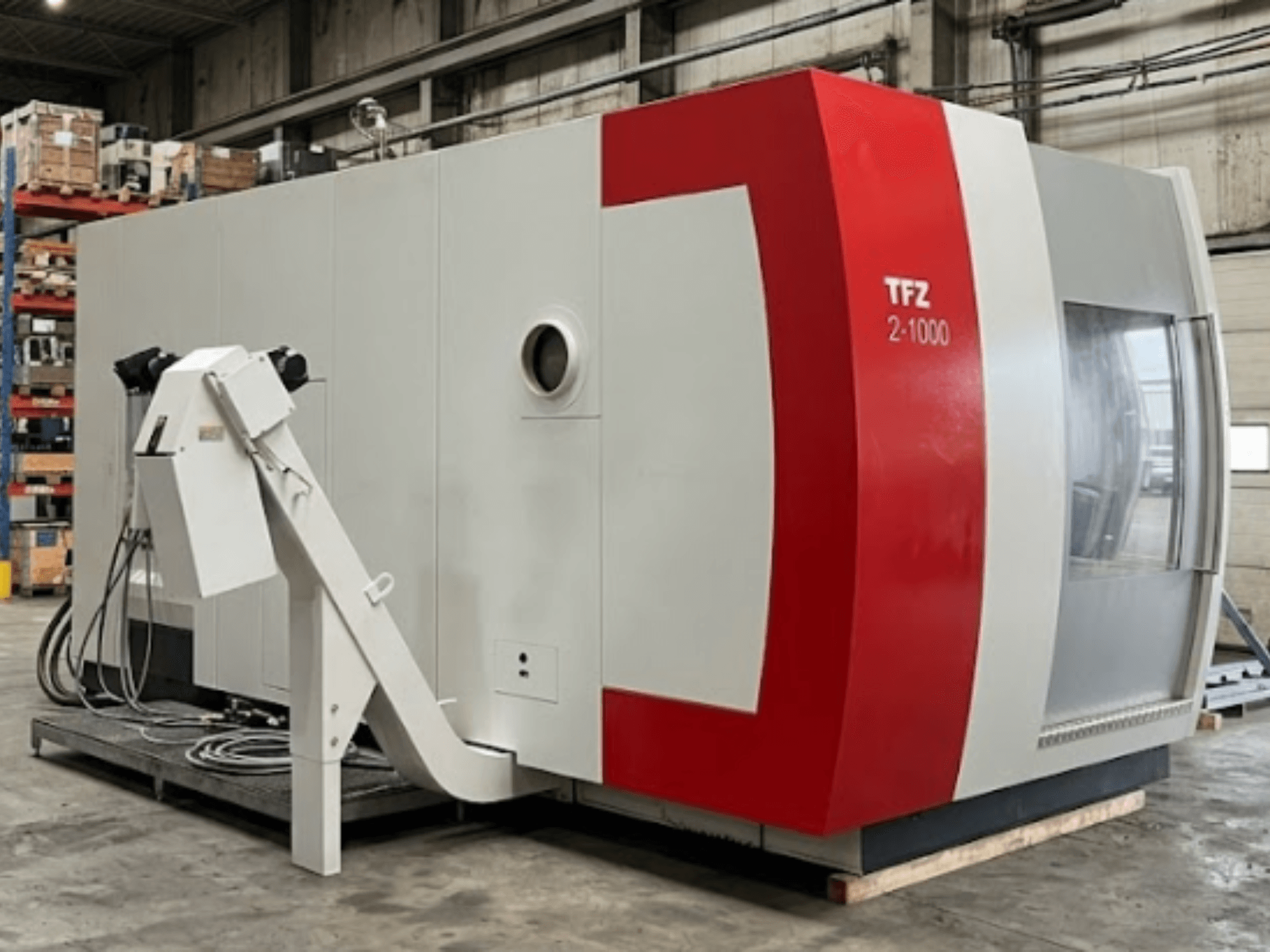 Universelles Bearbeitungszentrum SAMAG TFZ 2L-1000, Seitenansicht, die das rot-graue Design und den angebauten Roboterarm zeigt.