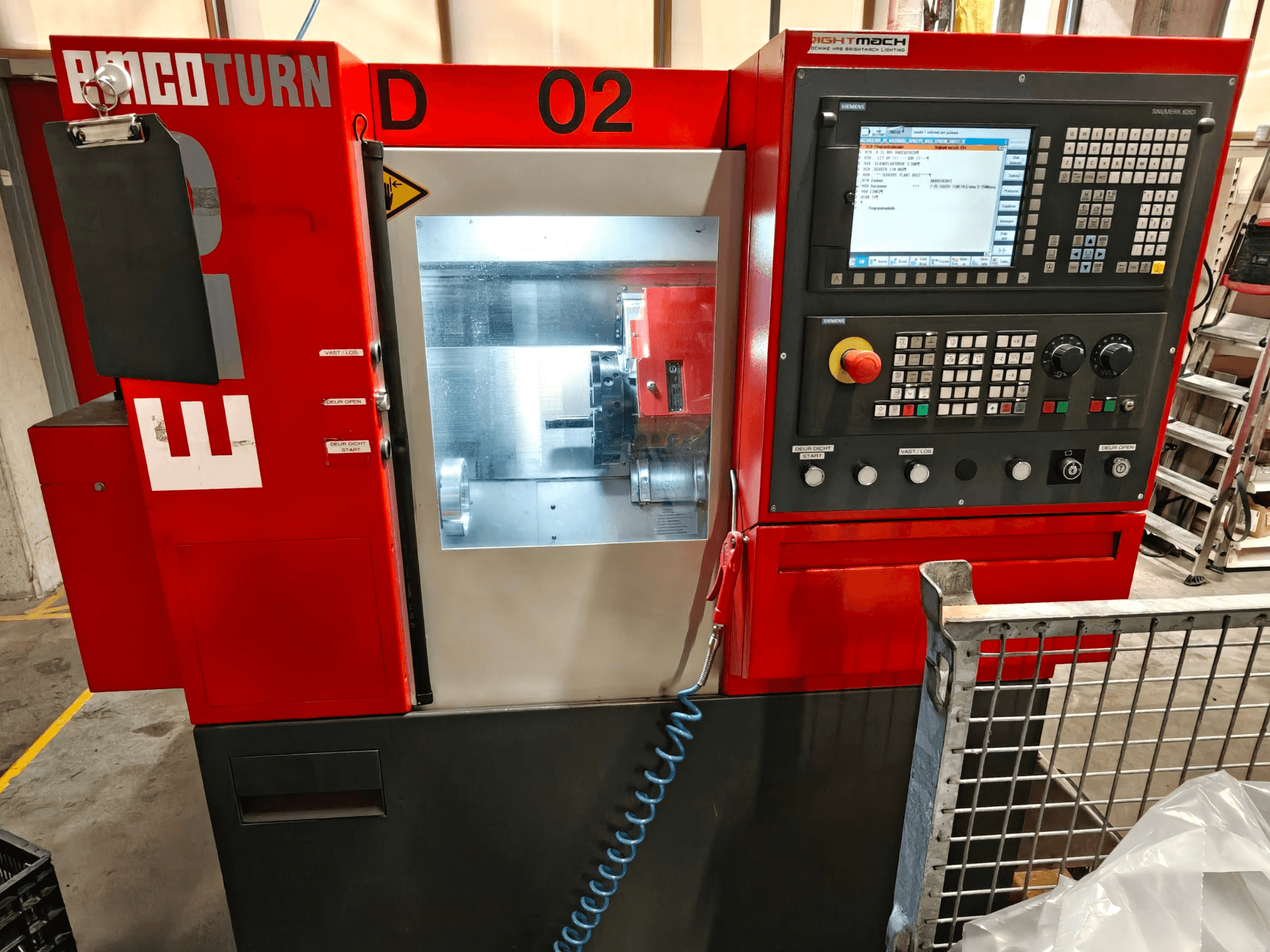 Vorderansicht der Horizontal-Drehmaschine EMCO TURN E25 mit Bedienfeld, Bildschirm und Bearbeitungsbereich.