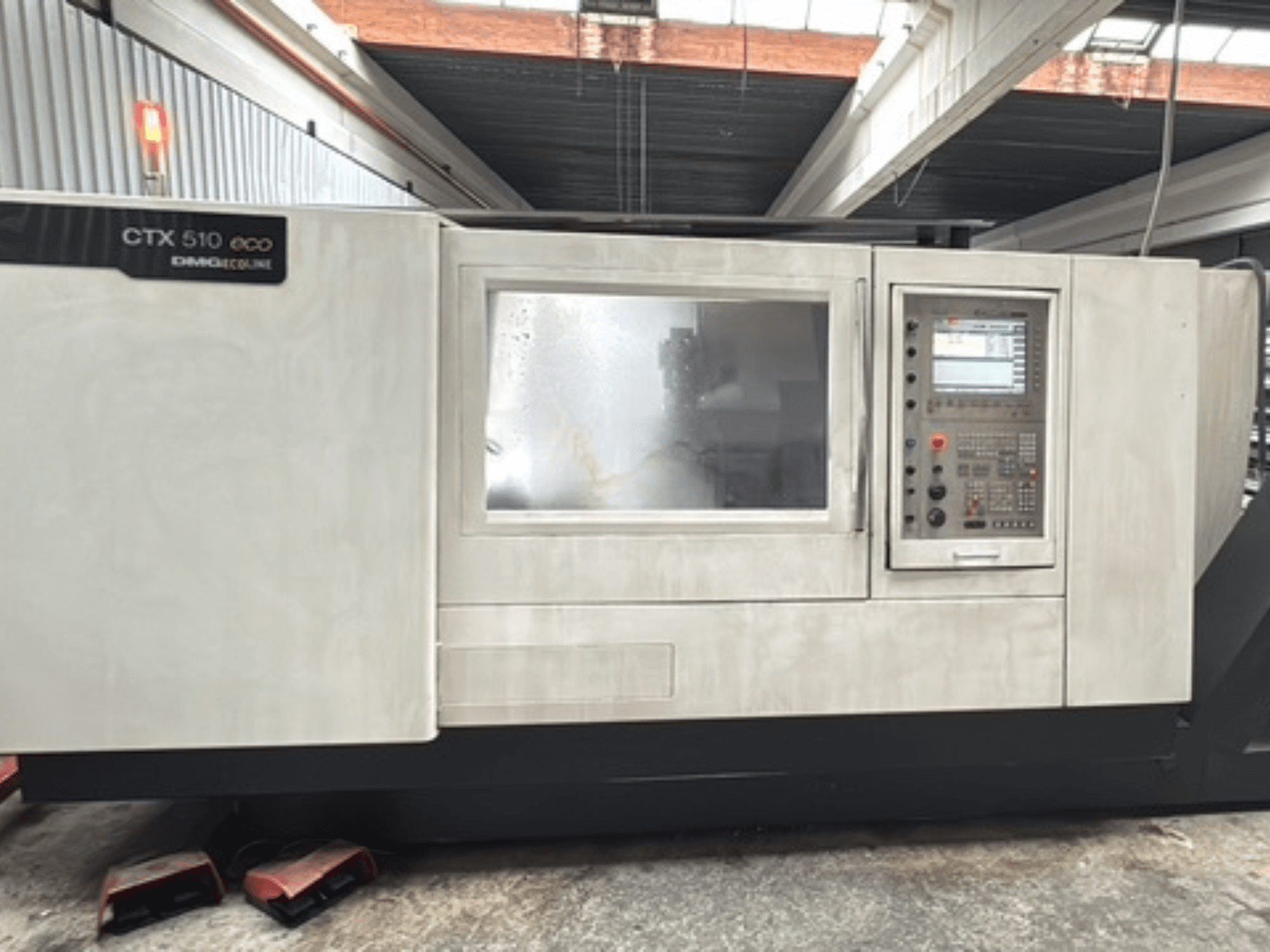 Horizontal-Drehmaschine DMG CTX 510 ecoline, Vorderansicht, mit Blick auf das Bedienfeld und das Fenster am Maschinenkörper.