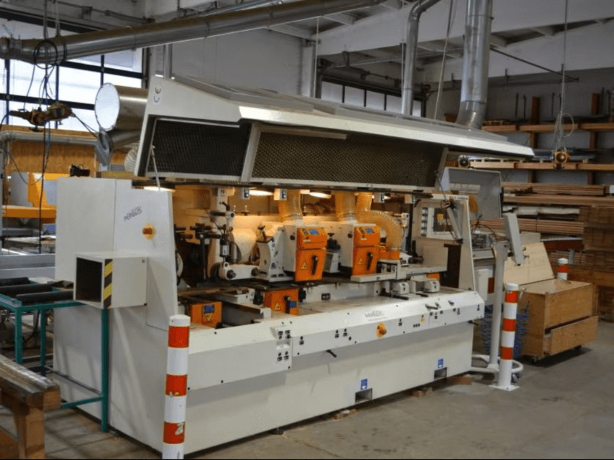 PENIGAS Holzbearbeitungsmaschine, Vorderansicht, mit zwei orangefarbenen Schneidköpfen und Staubabsaugung in einer Werkstatt.