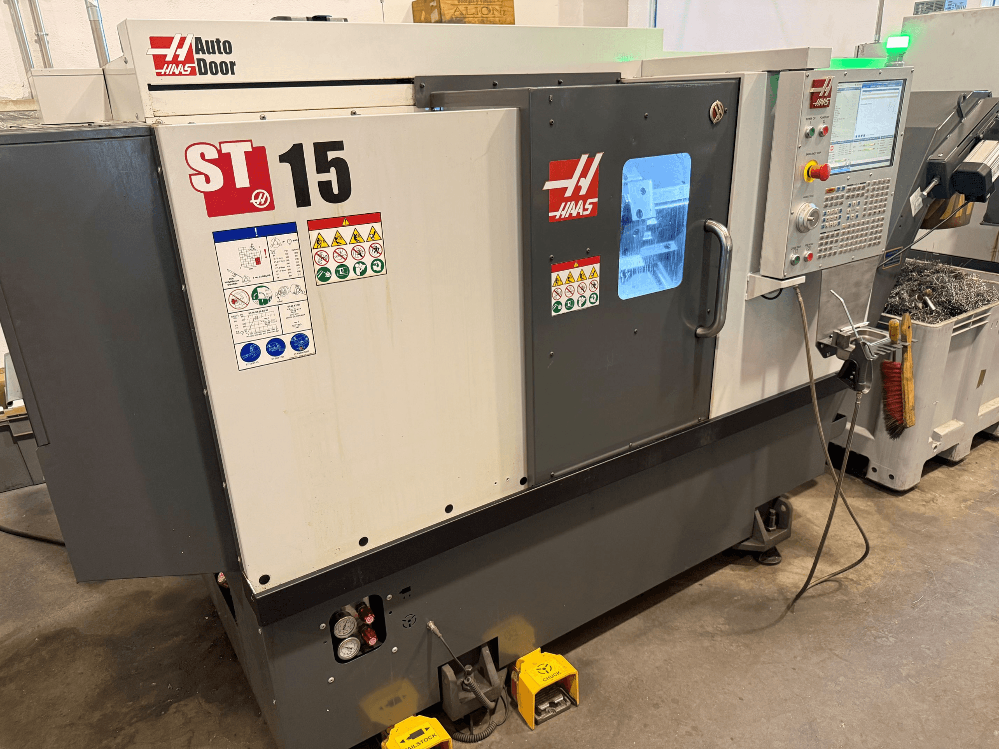 HAAS ST 15 Horizontal-Drehmaschine, Vorderansicht mit Bedienfeld, automatischer Tür und sichtbaren technischen Anzeigen.