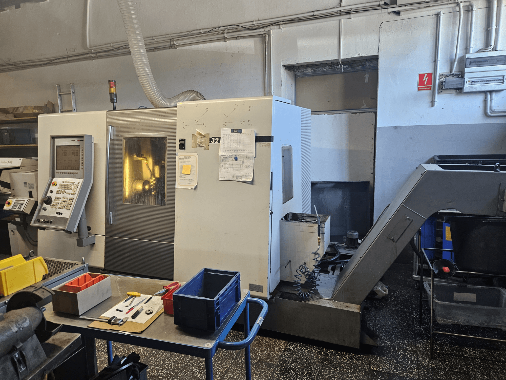 Mehrspindeldrehmaschine DMG GILDEMEISTER Sprint 32 linear, Vorderansicht in einer Werkstatt, mit Bedienpult und Werkzeugen sichtbar.