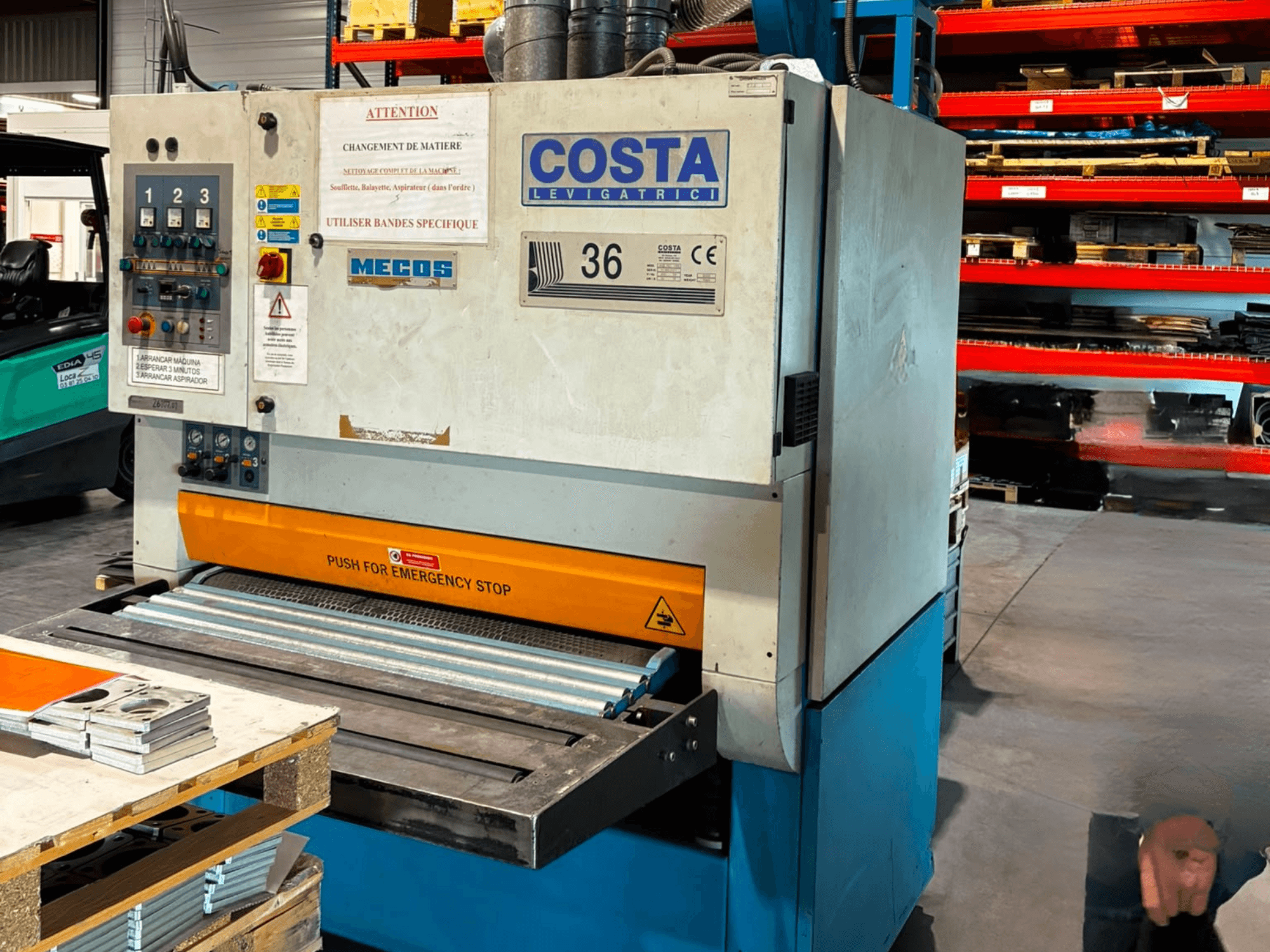 Entgratmaschine Costa M36 CCS 1150 in Seitenansicht, mit Bedienfeld, Not-Aus-Schalter und Förderband.