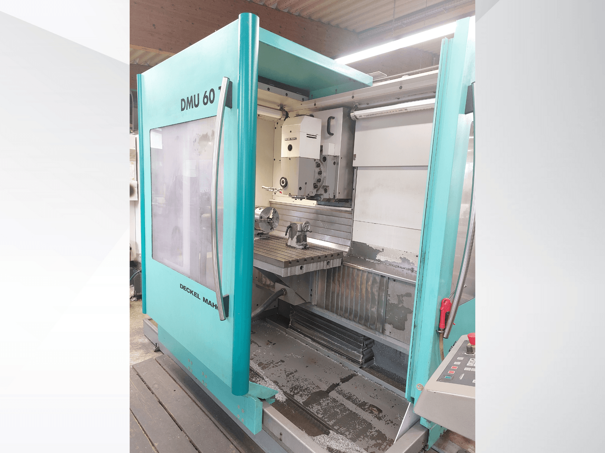 Deckel MAHO DMU 60 CNC-Maschine, Vorderansicht. Mit sichtbarem Bedienfeld und Frästisch mit Werkstückeinrichtung.