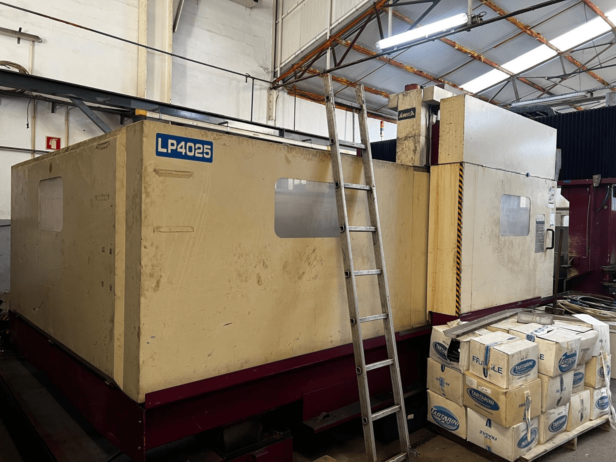 Portalfräsmaschine AWEA LP4025 in einer Industrieumgebung, Seitenansicht mit den großen Maschinen und Lagerboxen.