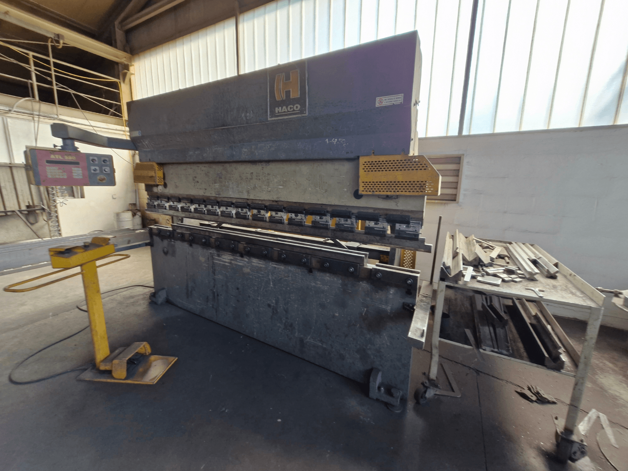 HACO PPM 30135 b Abkantpresse in einer Werkstatt, Vorderansicht mit Bedienfeld und Metallschrott auf einem Tisch daneben.