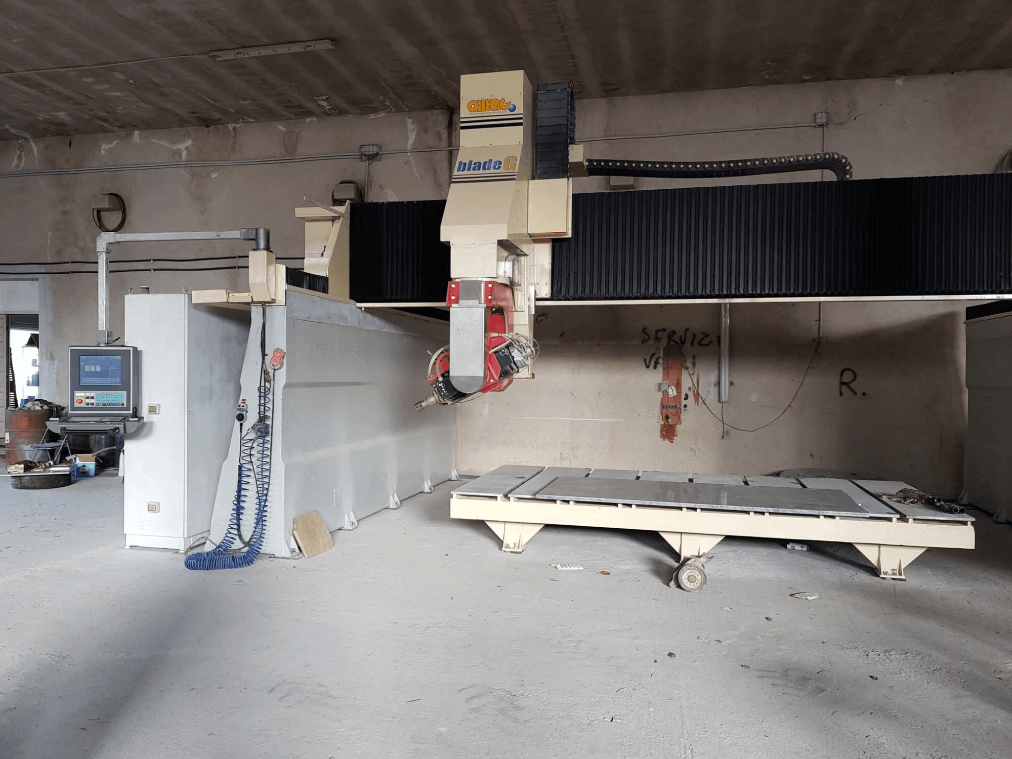 Portalfräsmaschine OMAG Blade G in einer Werkstatt, Vorderansicht mit Bedienpult und großem Fräsbett sichtbar.