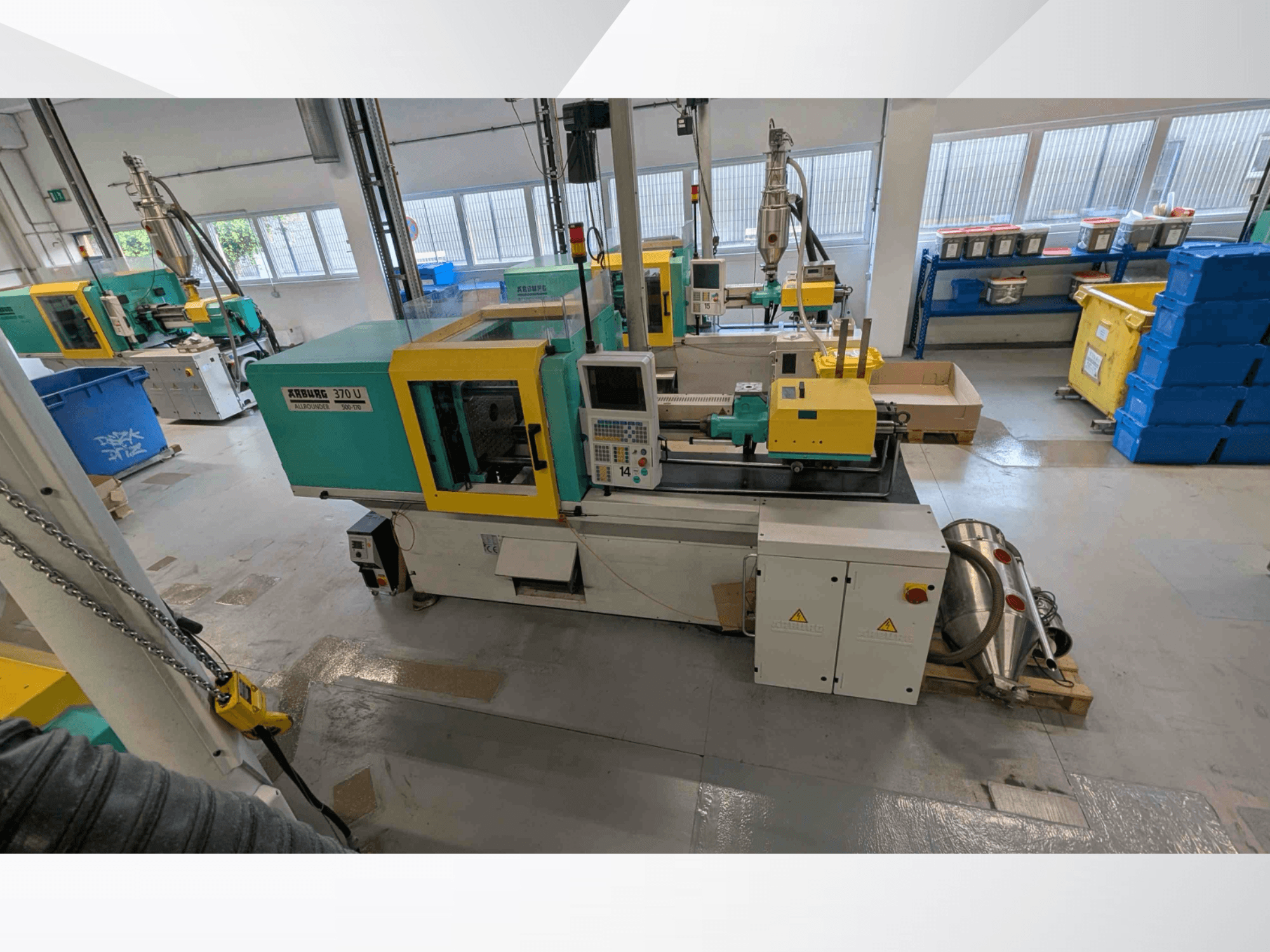 Vorderansicht einer vertikalen Spritzgießmaschine vom Typ Arburg 370 U 500-170 mit Bedienfeld und Maschinenkomponenten in einer Werkstatt.