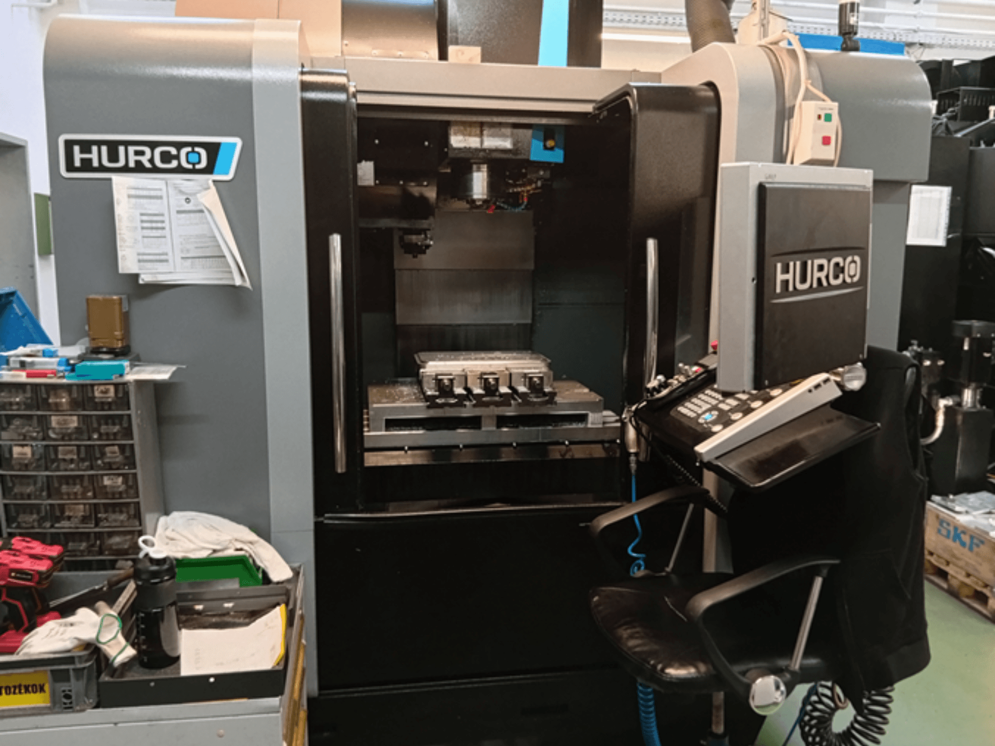 Hurco VMX 30i Vertikal-Bearbeitungszentrum in der Vorderansicht, mit Bedienfeld, Arbeitstisch und Betriebseinrichtung.
