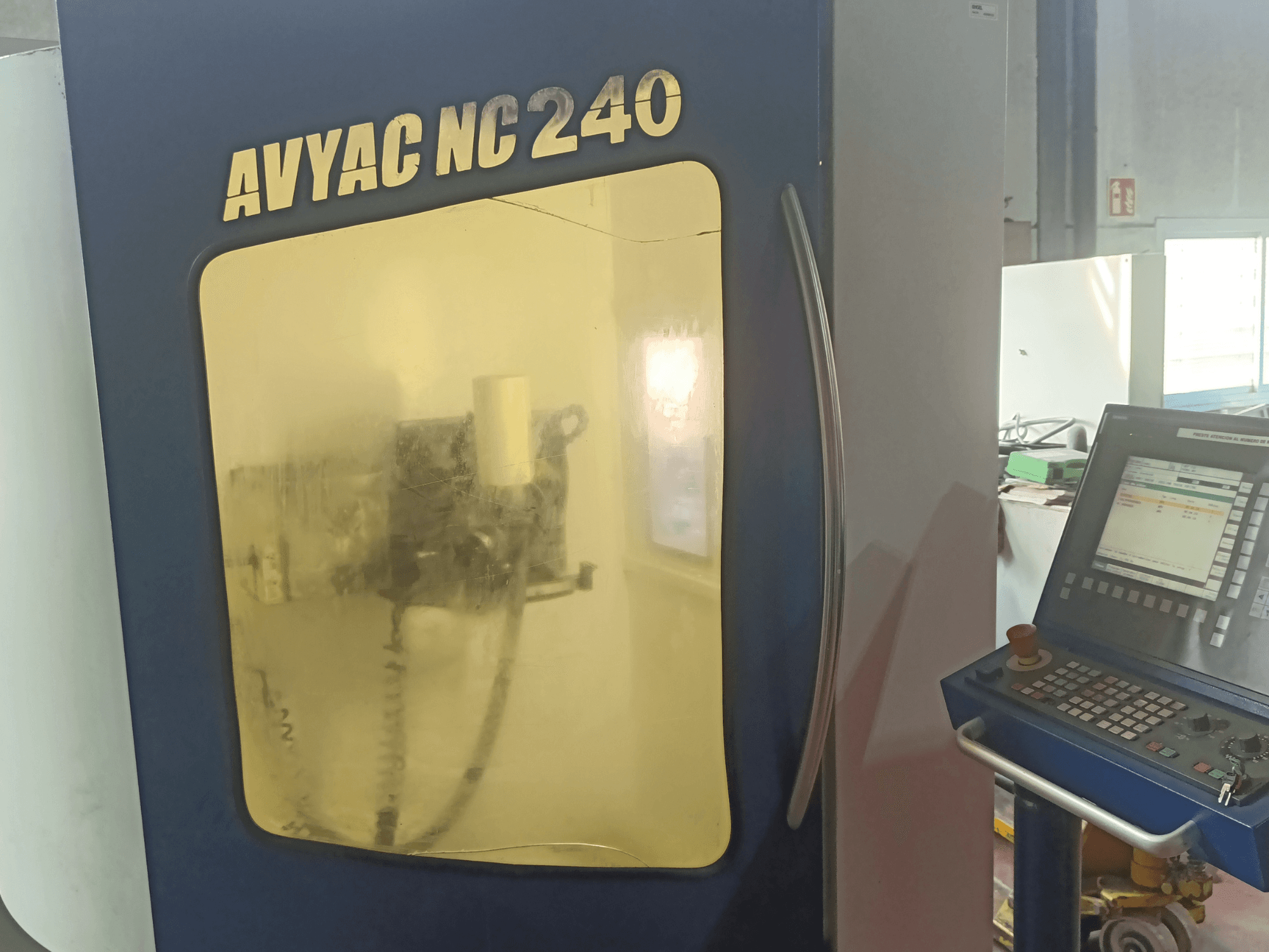 AVYAC NC240 Rundschleifmaschine, Seitenansicht mit Bedienfeld und teilweise sichtbarem Schleifbereich durch das Fenster.