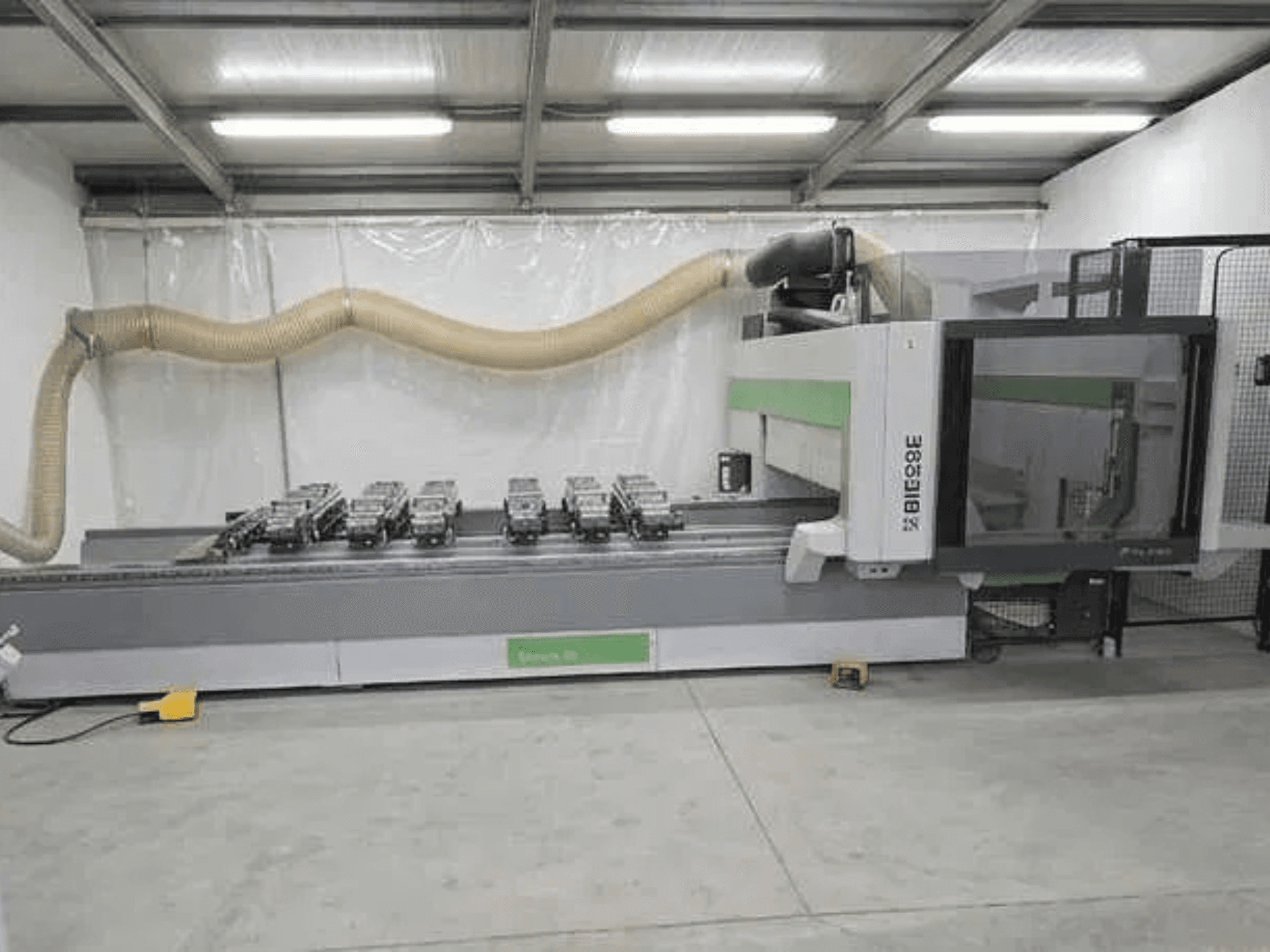 BIESSE Rover K1232 CNC-Bearbeitungszentrum in Seitenansicht, wobei die Vakuumsaugnäpfe und die Staubabsauganlage zu sehen sind.