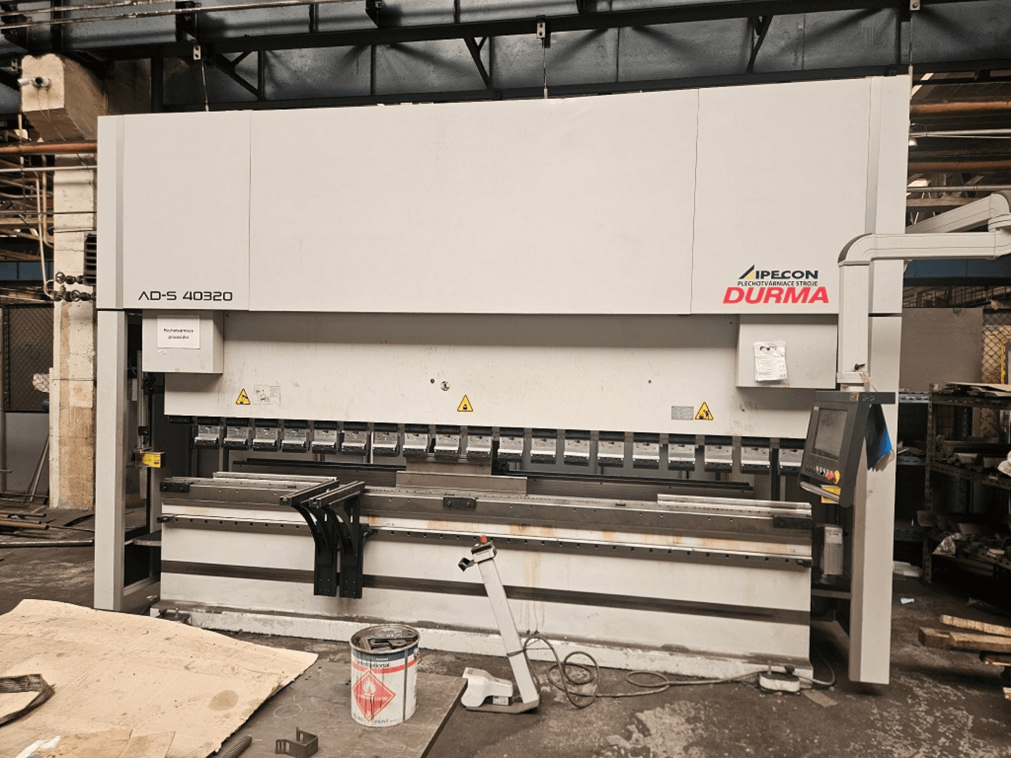 Abkantpresse Durma AD-S 40320 in Vorderansicht, mit Bedienfeld, Biegewerkzeugen und Sicherheitshinweisen in einer Werkstattumgebung.