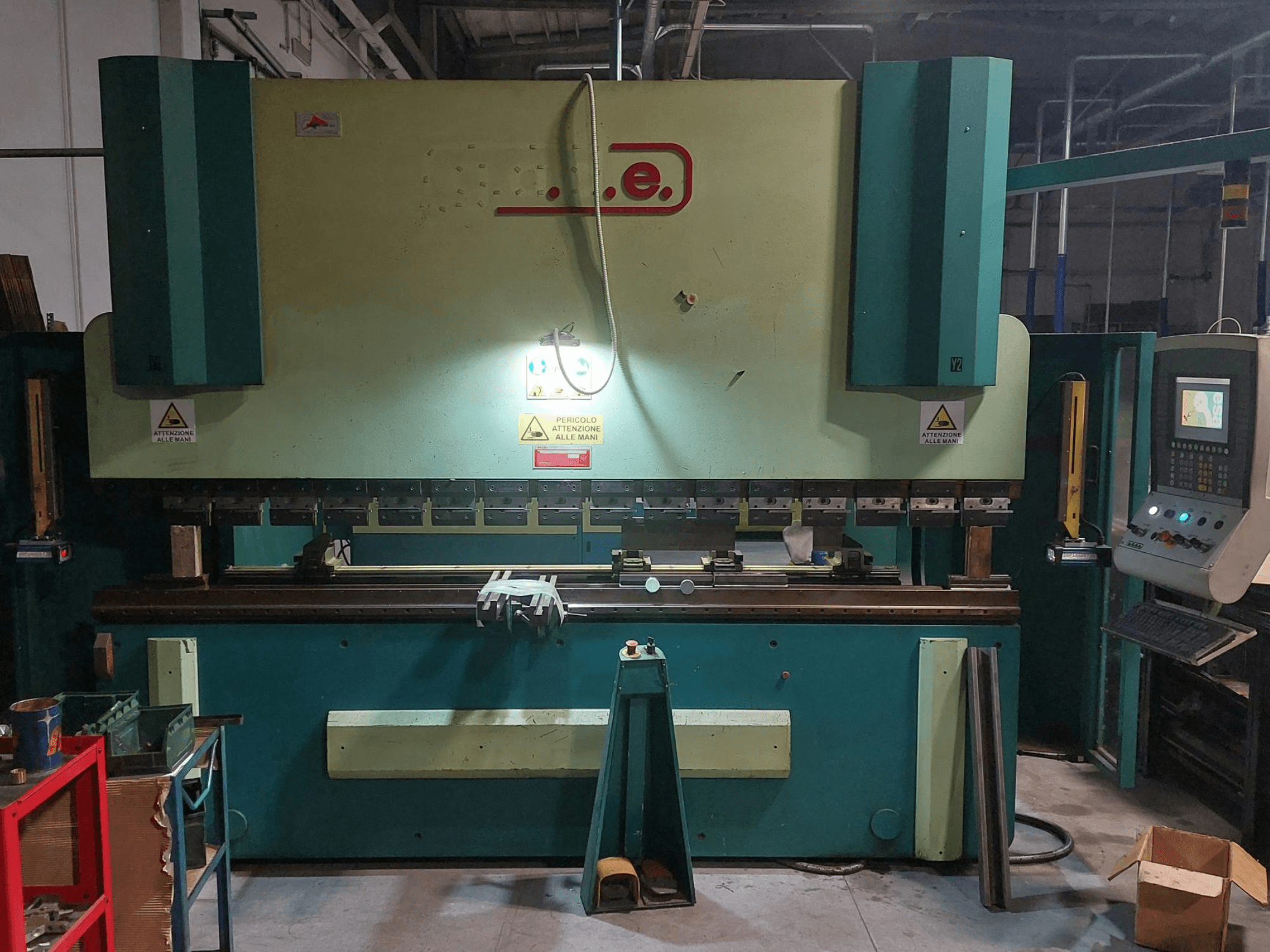 Vorderansicht der Abkantpresse Gade PS-C 3120 mit Bedienfeld, Sicherheitsschildern und Arbeitsbereich mit Werkzeugen und Materialien.