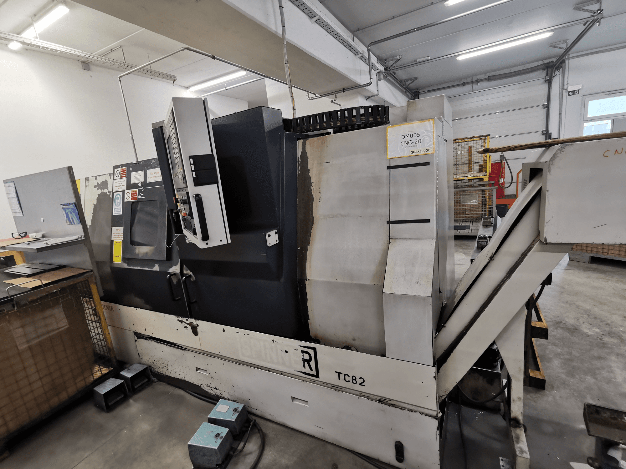 CNC-Maschine, Marke Spinner, Modell TC82, Seitenansicht mit Bedienfeld und Schrottabwurfschacht in einer Werkstatt.