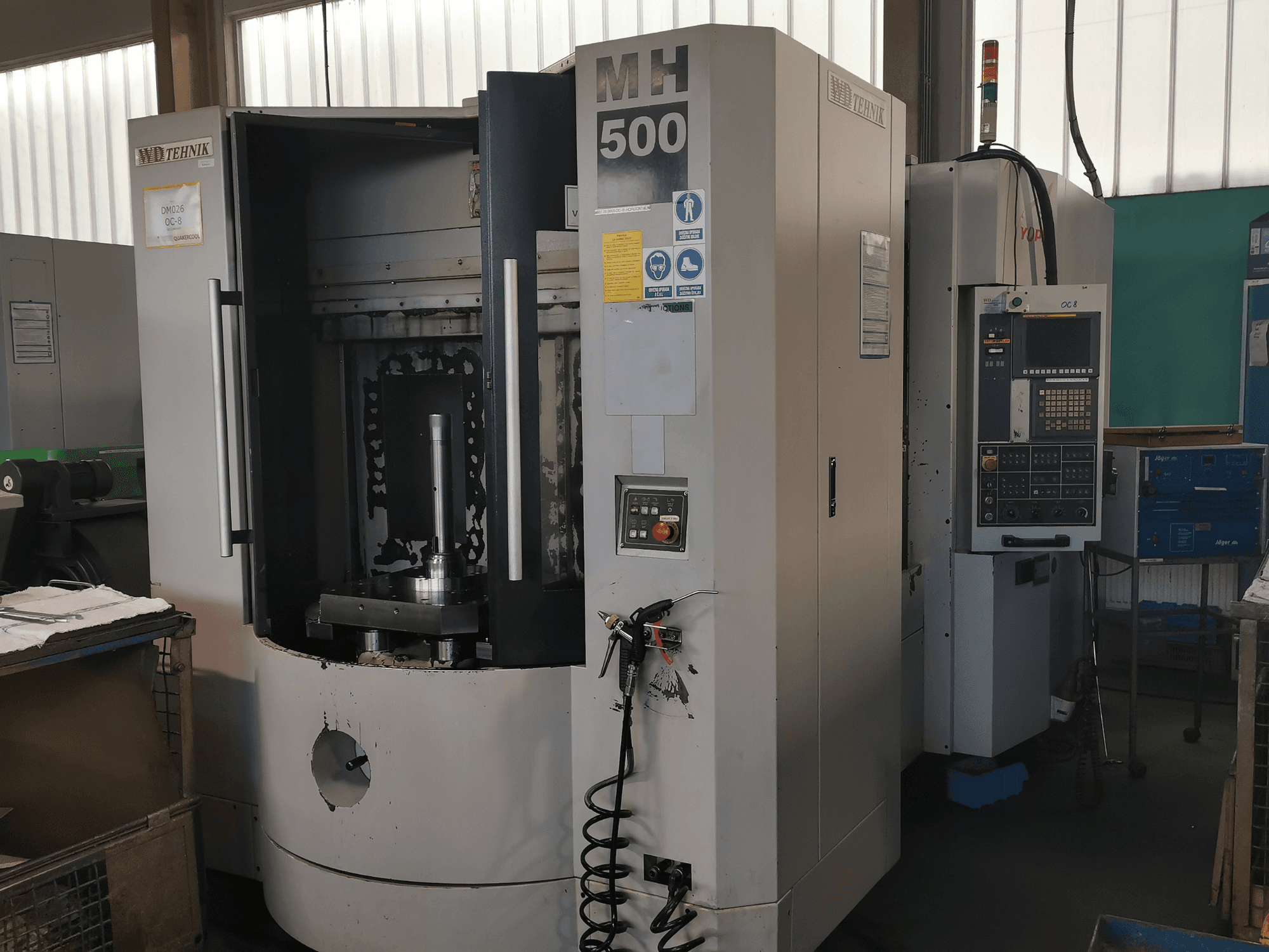 Bearbeitungszentrum MH 500 in einer Werkstatt, Vorderansicht; sichtbares Bedienfeld und Werkstückhalter im Inneren der Maschine.