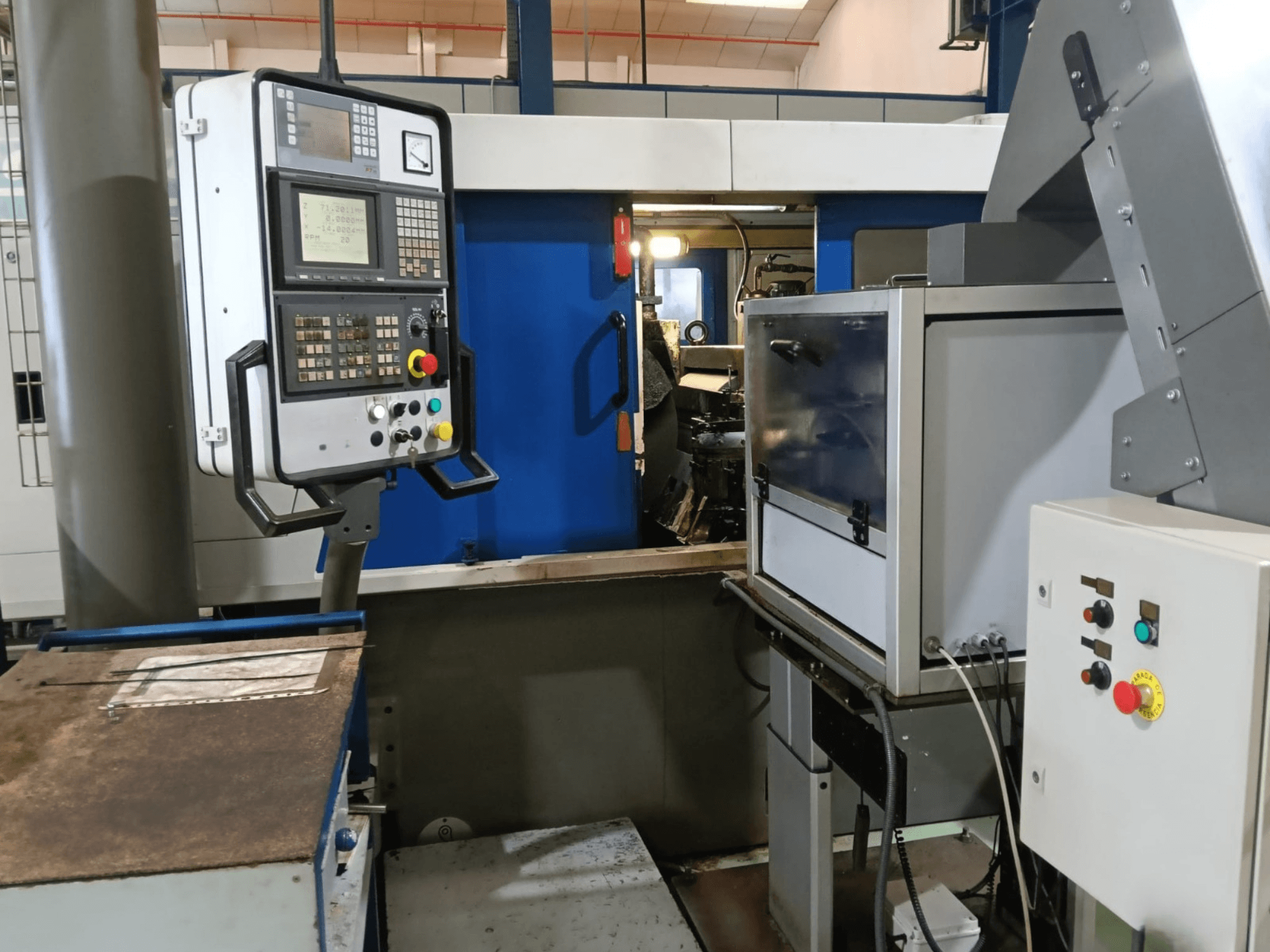 Bedienfeld und Maschinen der spitzenlosen Schleifmaschine DANOBAT 327 MDA, von der Seite gesehen, mit Tasten und Display.