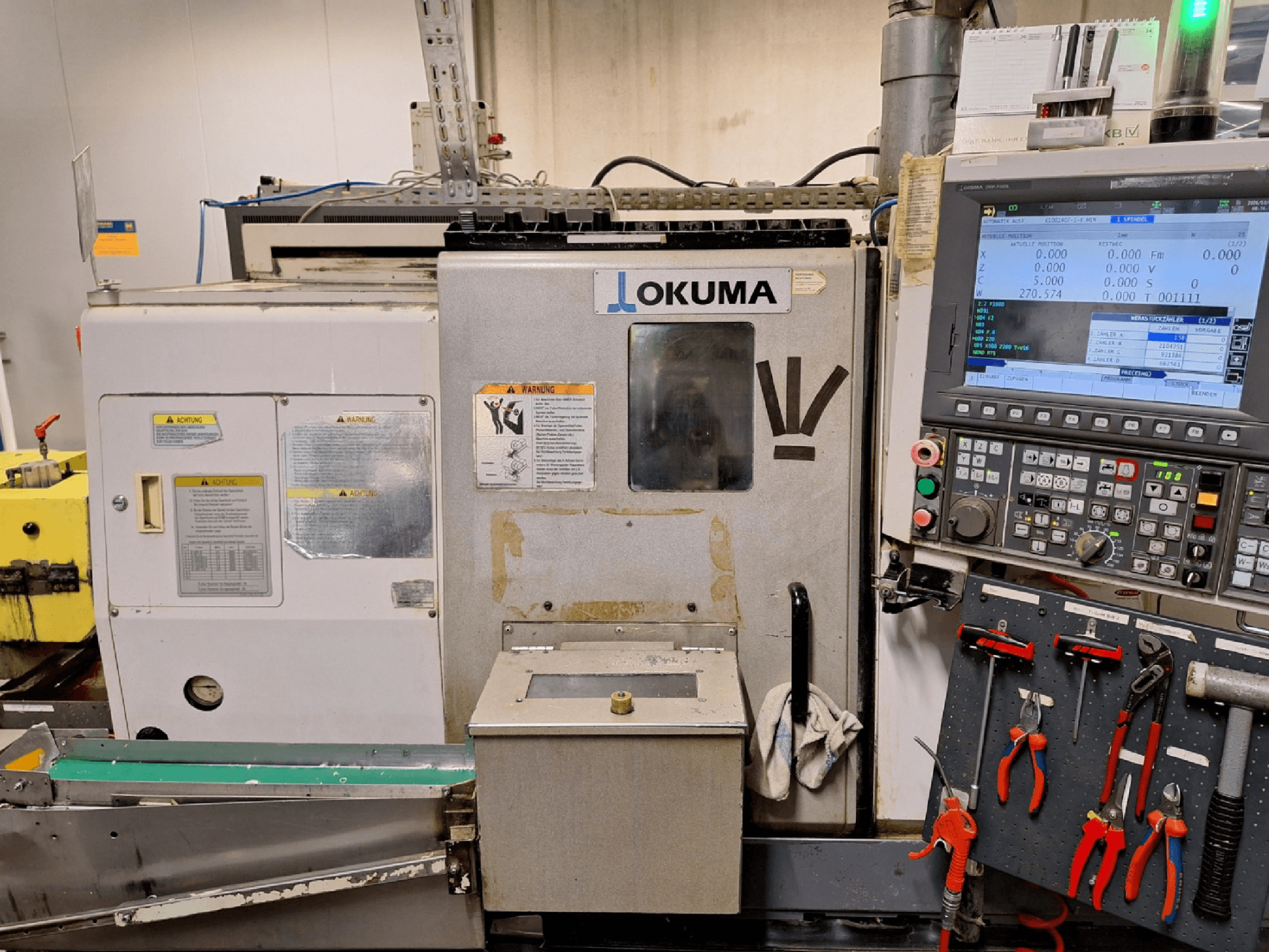 Okuma LB200-MW Horizontal-Drehmaschine, Vorderansicht, mit seitlich sichtbarem Bedienfeld und Werkzeugen.