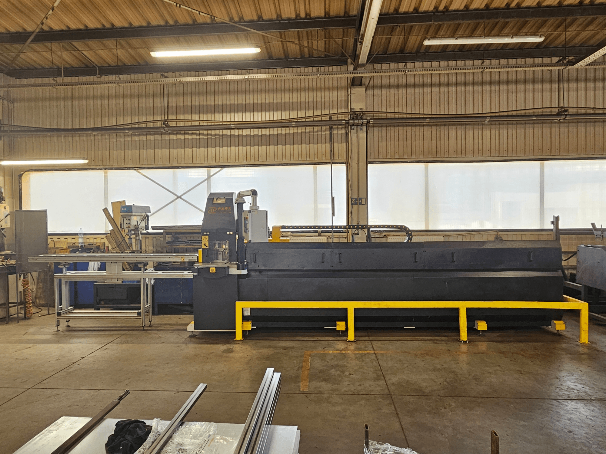 CNC-Stanzmaschine PARS HMP SIRIUS PLUS-3000/3-L1, Vorderansicht in einer industriellen Umgebung mit Metalloberflächen und Werkzeugen.