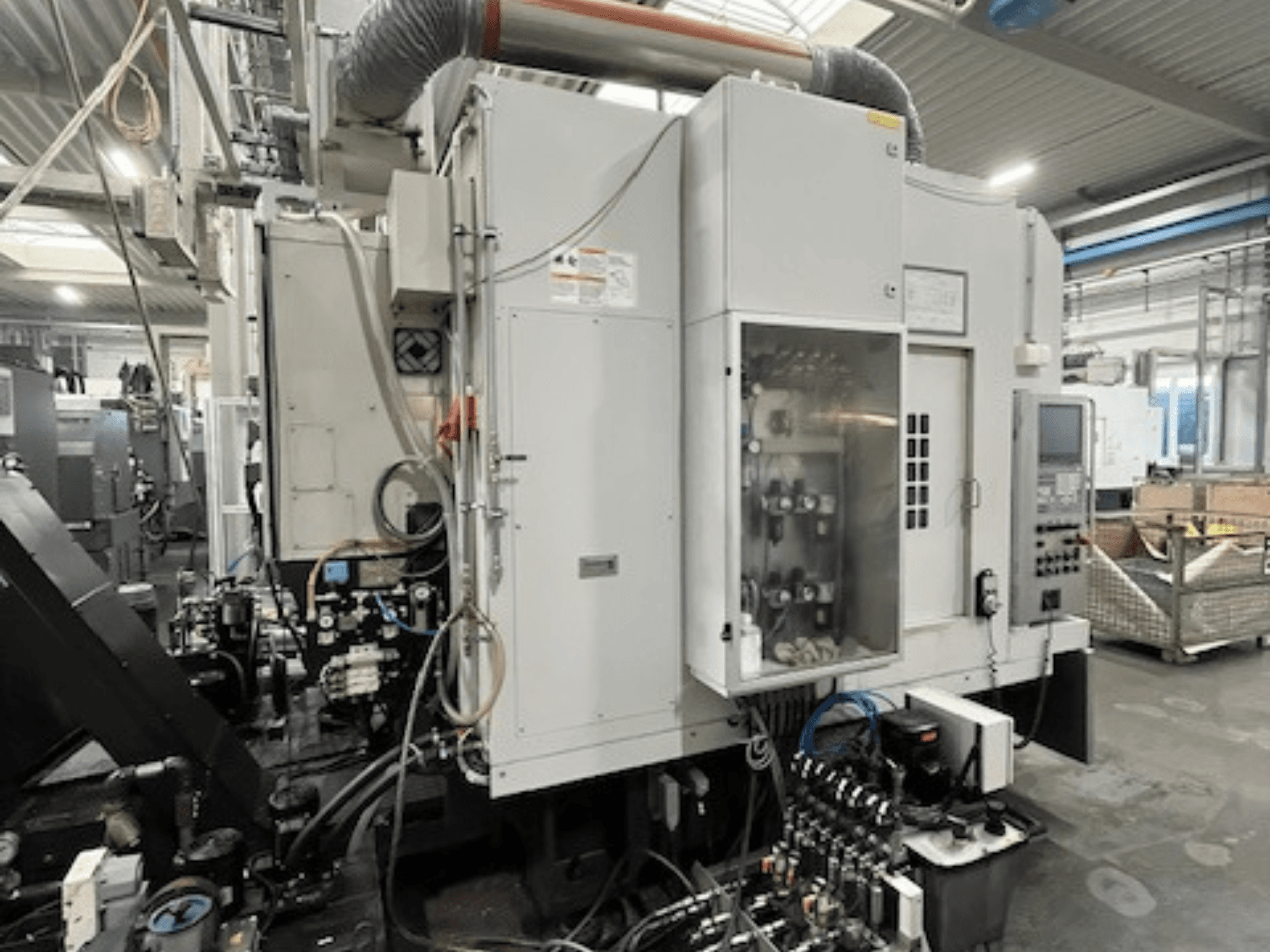 Seitenansicht einer Industriemaschine mit Bedienfeld und hydraulischen Komponenten, mit Angabe von Marke und Modell.