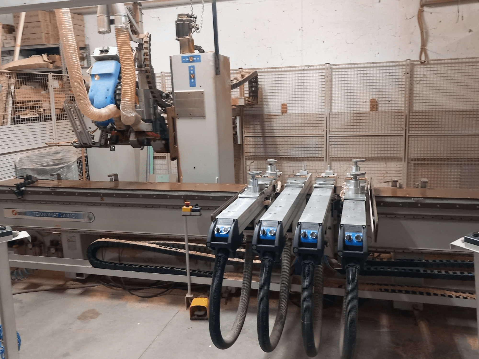 CNC-Holzbearbeitungszentrum MASTERWOOD TEKNOMAT 5000, Vorderansicht mit dem Werkzeugkopf und mehreren Absaugschläuchen.