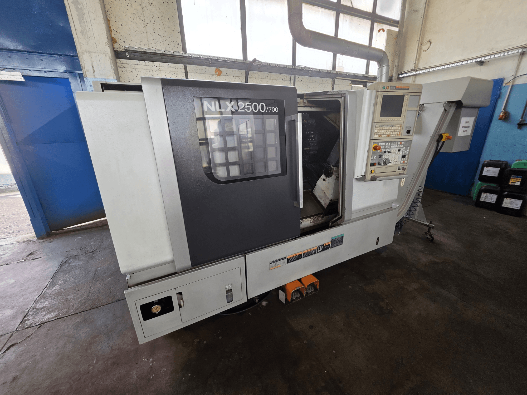 Horizontaldrehmaschine DMG MORI NLX 2500/700 in Seitenansicht, mit Bedienfeld und sichtbarem Bearbeitungsbereich.