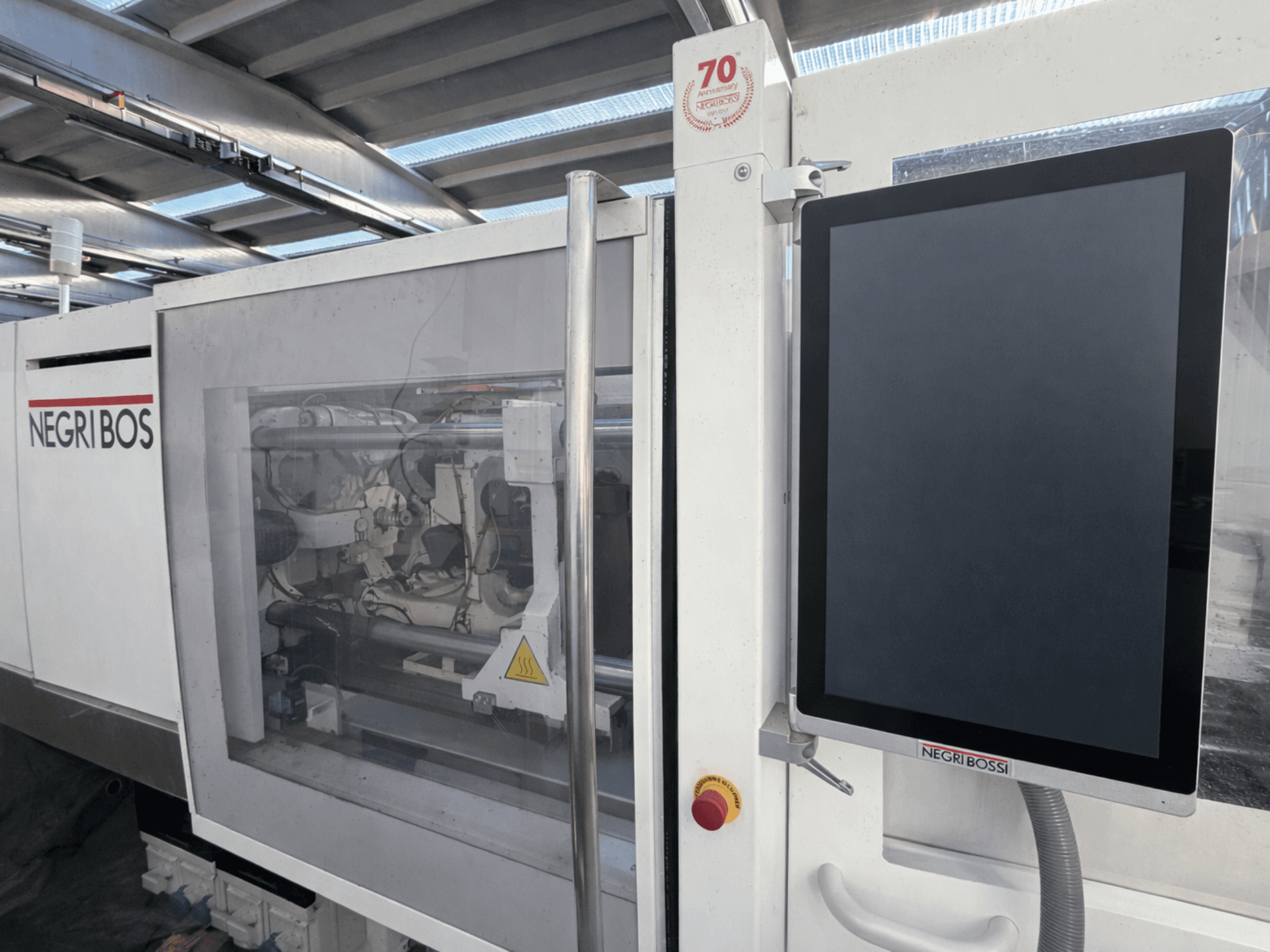 Elektrische Spritzgießmaschine Negri Bossi ELE 80, Vorderansicht mit Kontrollbildschirm und sichtbaren internen Komponenten.