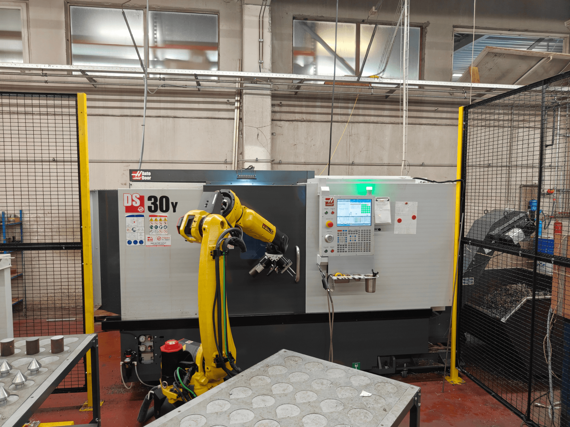 HAAS DS30Y Horizontal-Drehmaschine mit Roboterarm, Vorderansicht, mit Blick auf das Bedienfeld und den Arbeitsbereich.