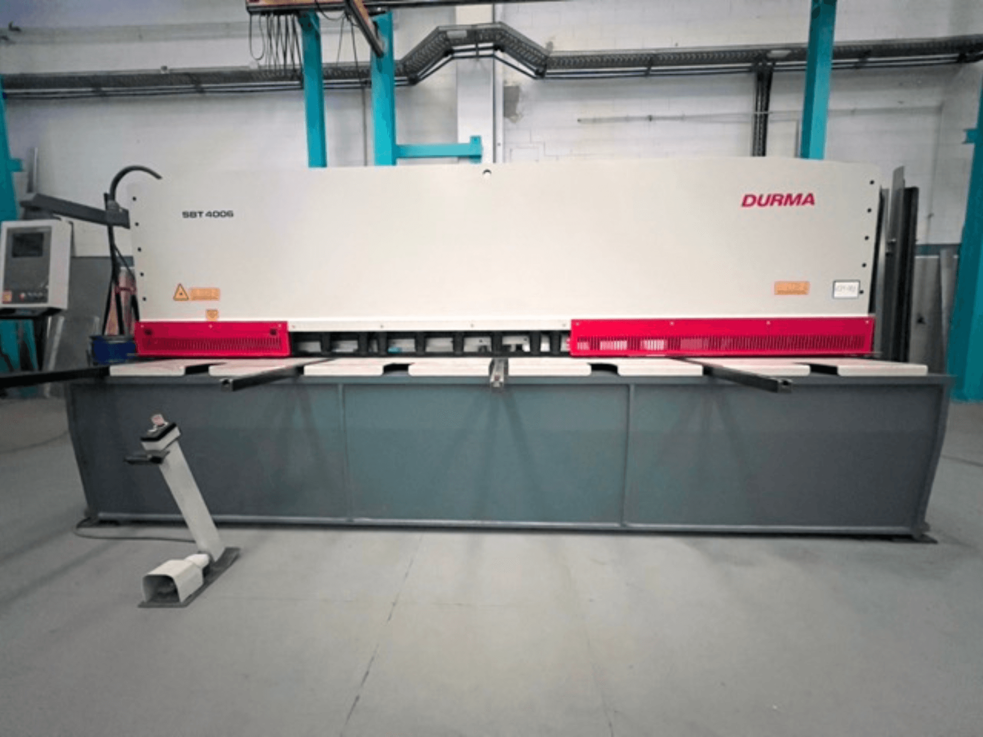 CNC-Schneidemaschine Durma SBT 4006 in der Frontansicht, mit grauem Sockel und roten Akzenten, bereit für den Einsatz in einer Fabrikumgebung.