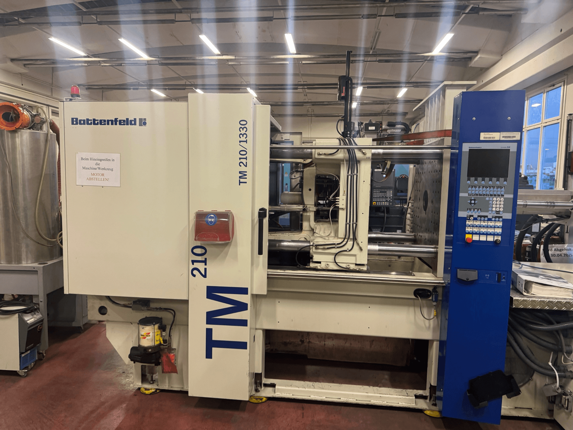 Hydraulische Spritzgießmaschine Battenfeld TM 210/1330, Vorderansicht, mit Bedienfeld und Maschinenkomponenten.