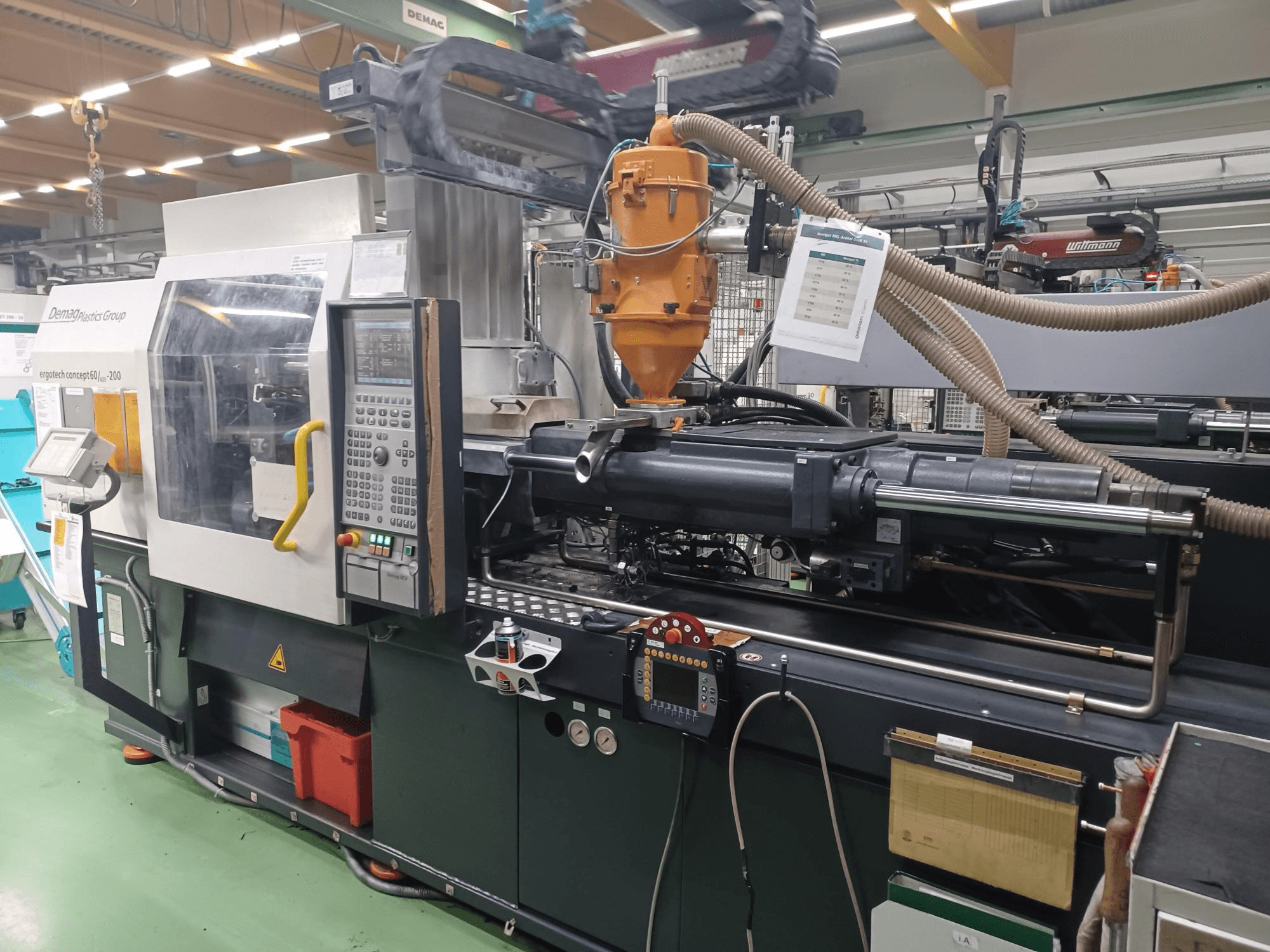 Demag Ergotech 200-Spritzgießmaschine, Vorderansicht, mit Bedienfeld, Düse und Betriebsteilen sichtbar.