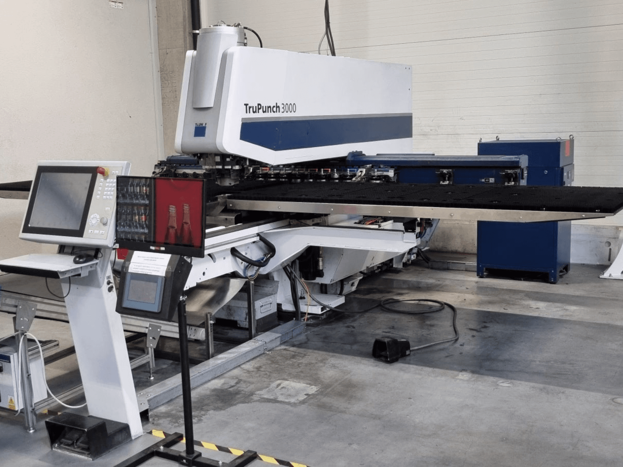 CNC-Stanzmaschine TRUMPF TruPunch 3000 in Frontansicht, mit Bedienfeld und großem Stanztisch.