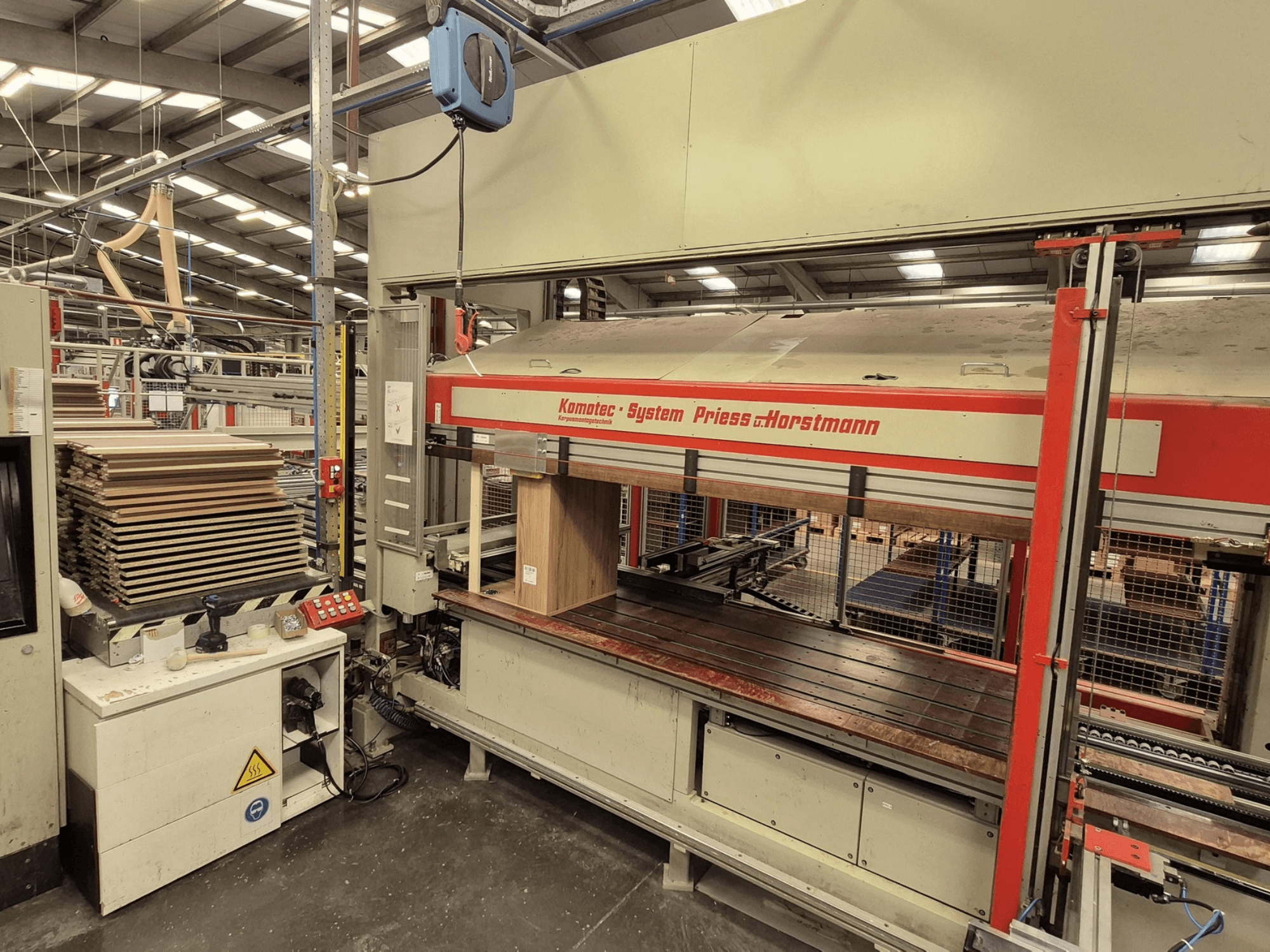 Furnierpresse KP-5-CNC von PREISS U HORTSTMANN, Vorderansicht, mit gestapelten Furnierblättern und Bedienfeld.