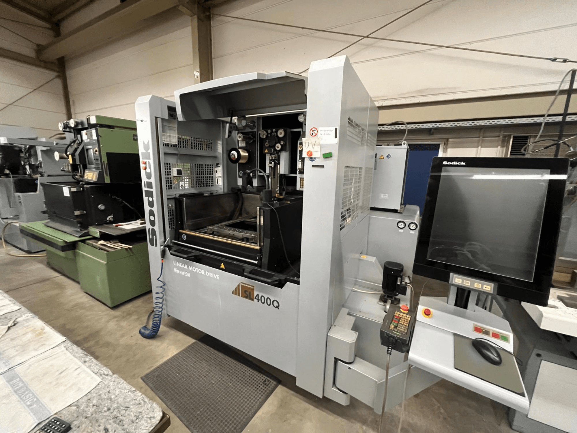 Sodick SL400Q CNC-Maschine mit Linearmotorantrieb, Frontansicht mit digitaler Steuertafel und Display in einer Werkstattumgebung.