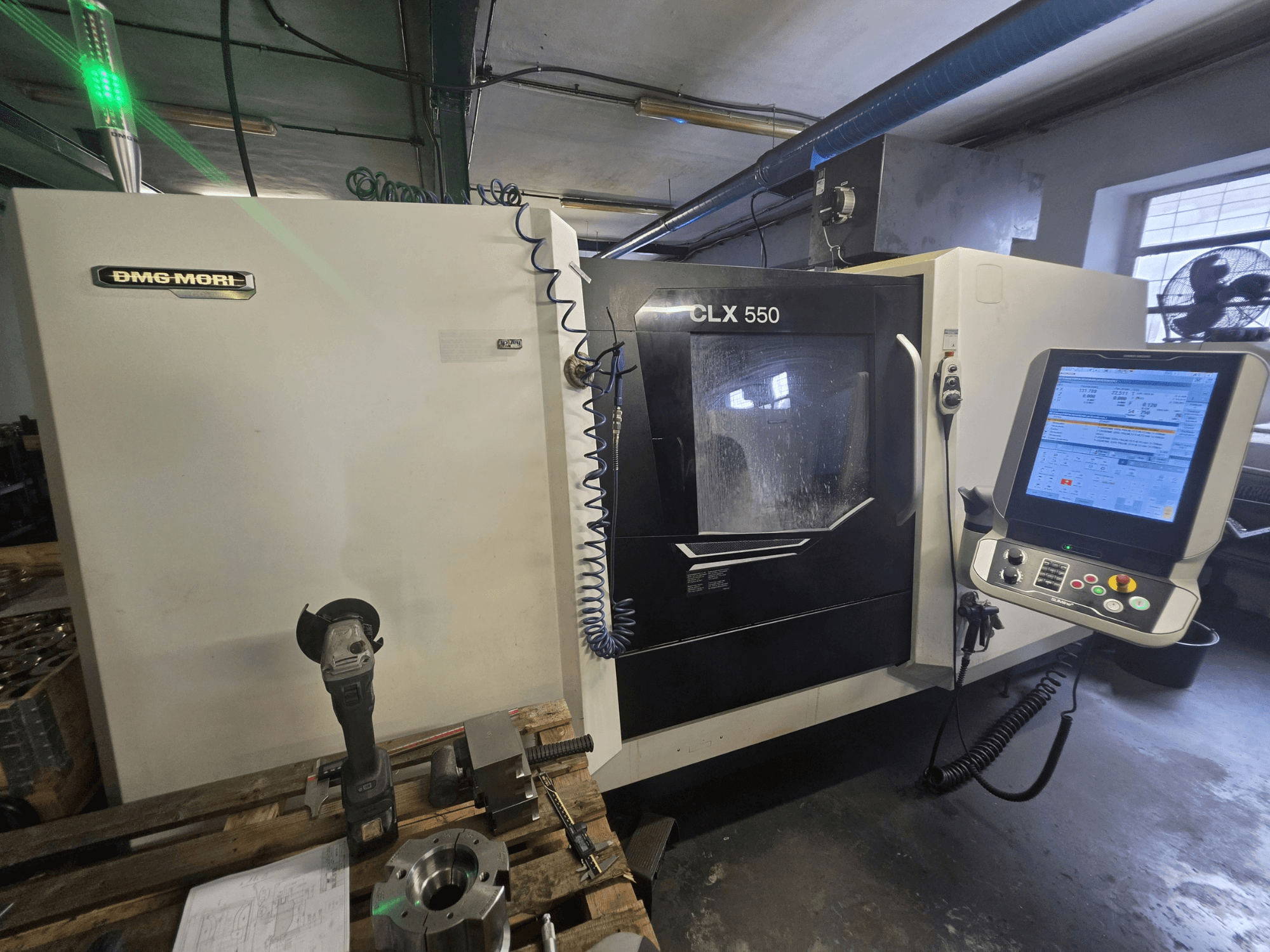 Horizontaldrehmaschine DMG MORI CLX 550 V3, Vorderansicht mit Bedienfeld, Schneidwerkzeugen und Maschinengehäuse.