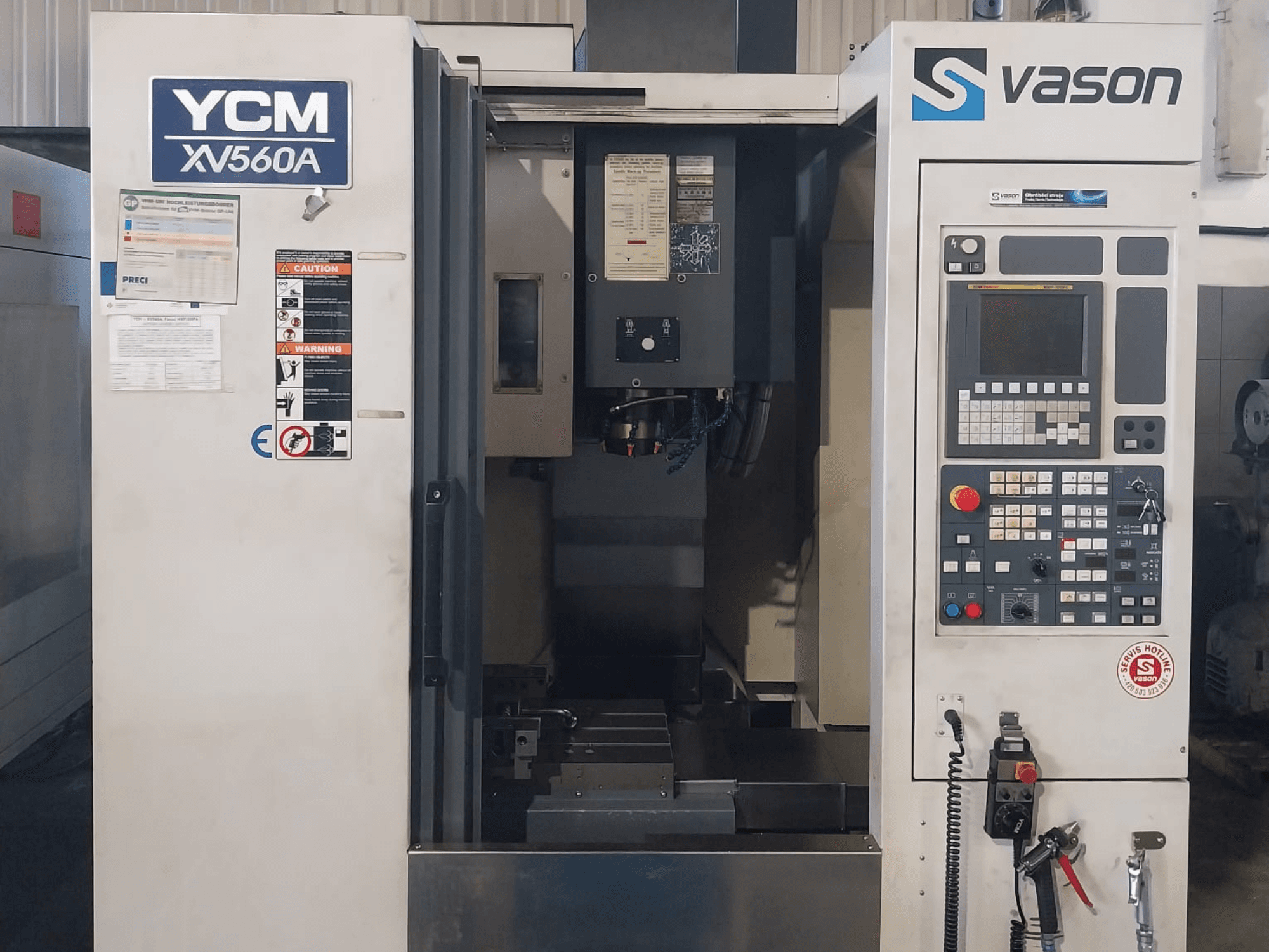 Vorderansicht des Vertikal-Bearbeitungszentrums YCM XV 560A mit Bedienpult und Arbeitstisch mit sichtbaren Bearbeitungselementen.