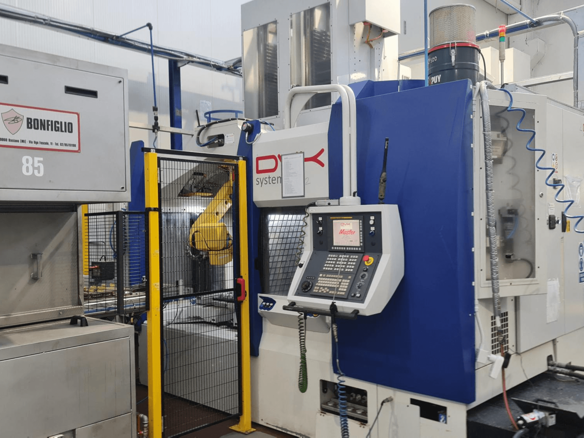Horizontales Bearbeitungszentrum „DVK System Master“, Vorderansicht, mit Bedienfeld, Schutzzaun und Roboterarm.