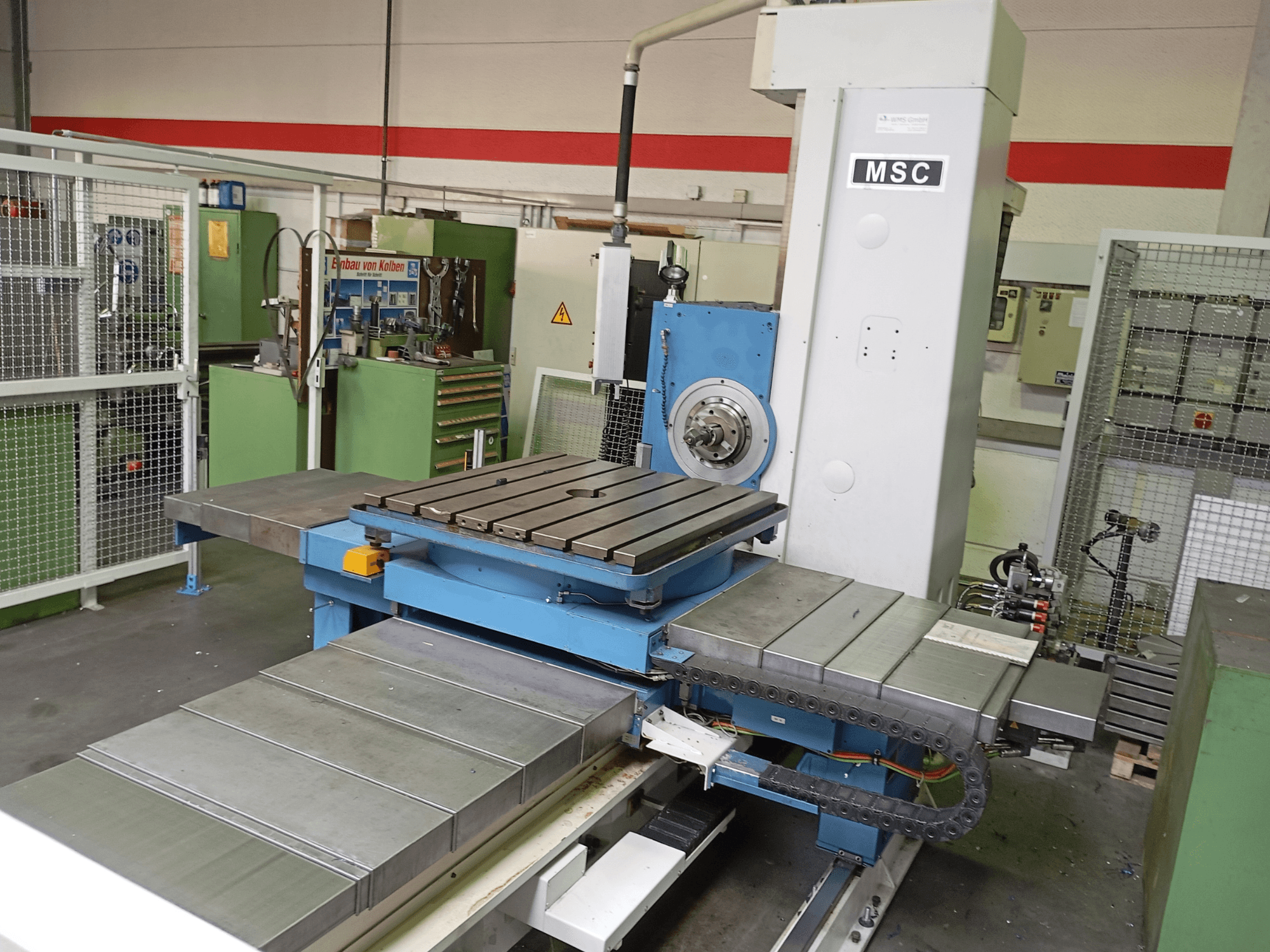 Bohrmaschine MSC BFT 90/5 TNC 320, Seitenansicht, mit Metallarbeitstisch und Werkzeughalter in einer Werkstattumgebung.