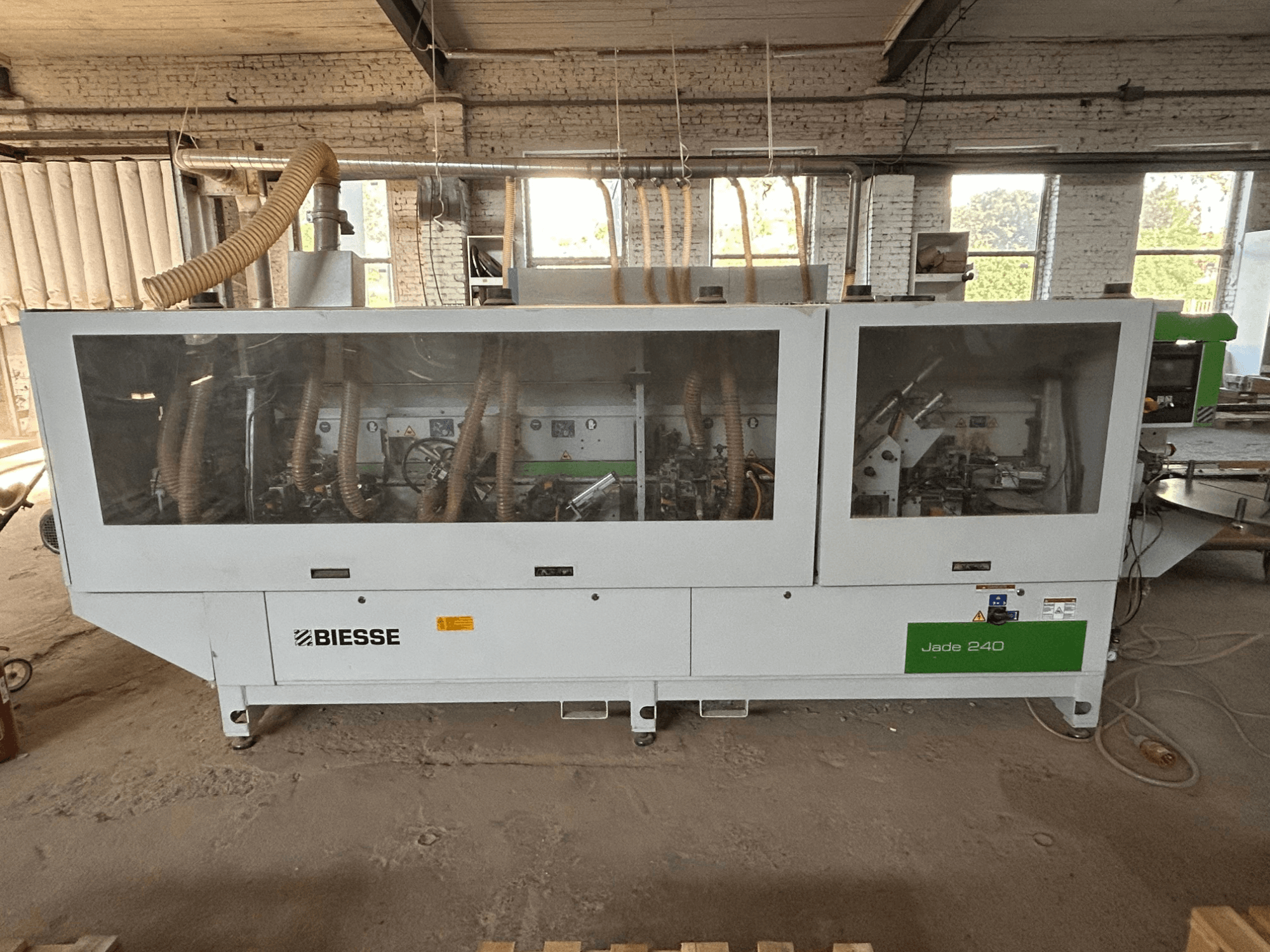 Kantenanleimmaschine BIESSE Jade 240 in Weiß und Grün, Vorderansicht mit Bedienfeld und detailliertem Blick auf das Maschineninnere.