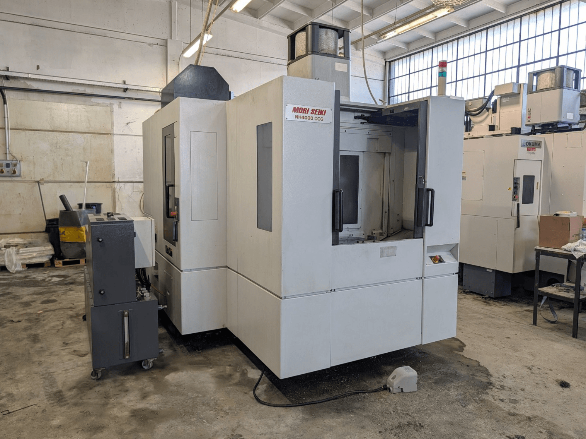 MORI SEIKI NH 4000 DCG Horizontal-Bearbeitungszentrum, Vorderansicht, mit Bedienfeld und Arbeitsbereich, grau-weiß lackiert.