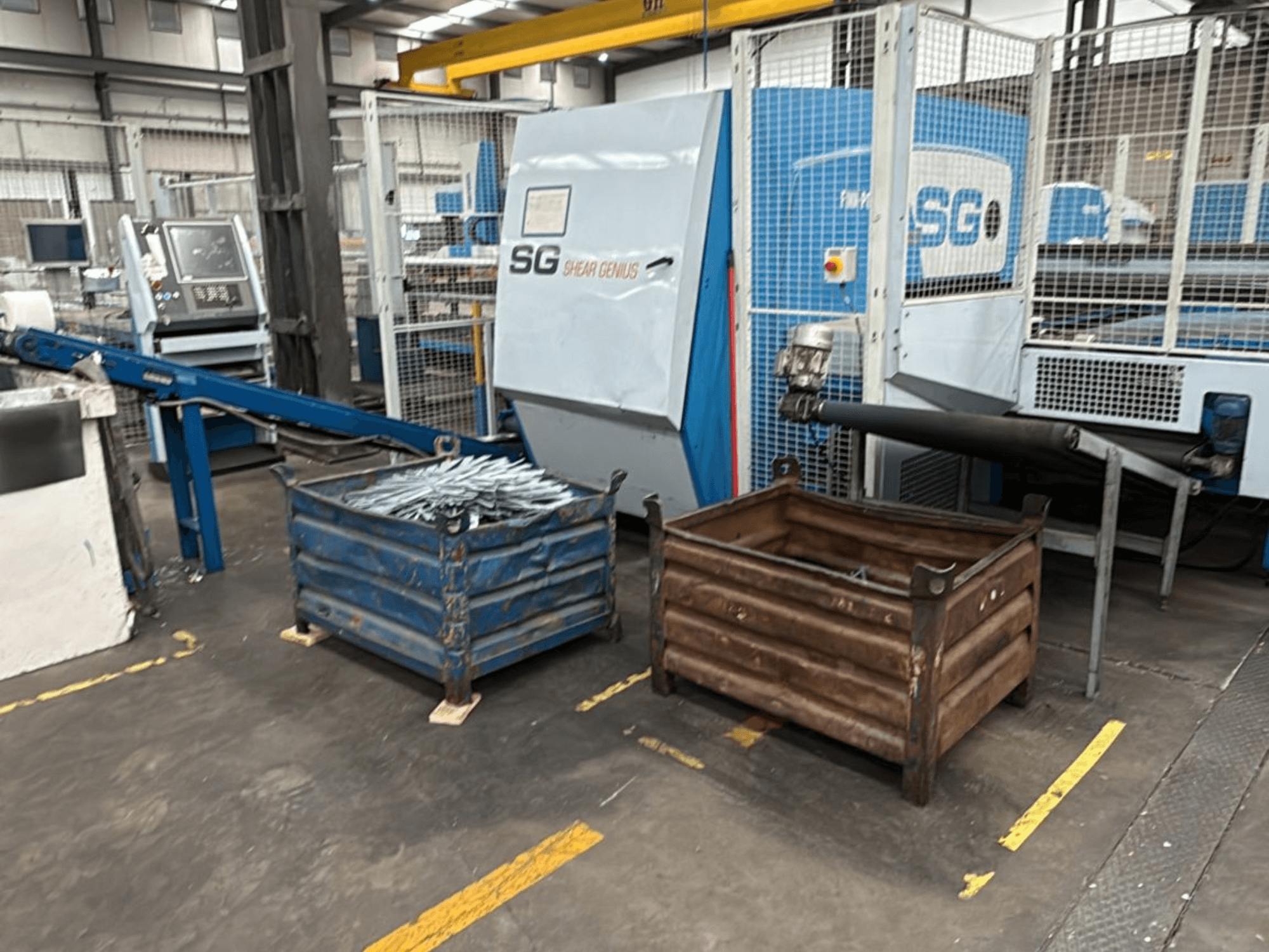Finn-Power SG6 12.61 Stanz- und Biegemaschine, Vorderansicht mit Metallbehältern daneben in einer Werkstattumgebung.