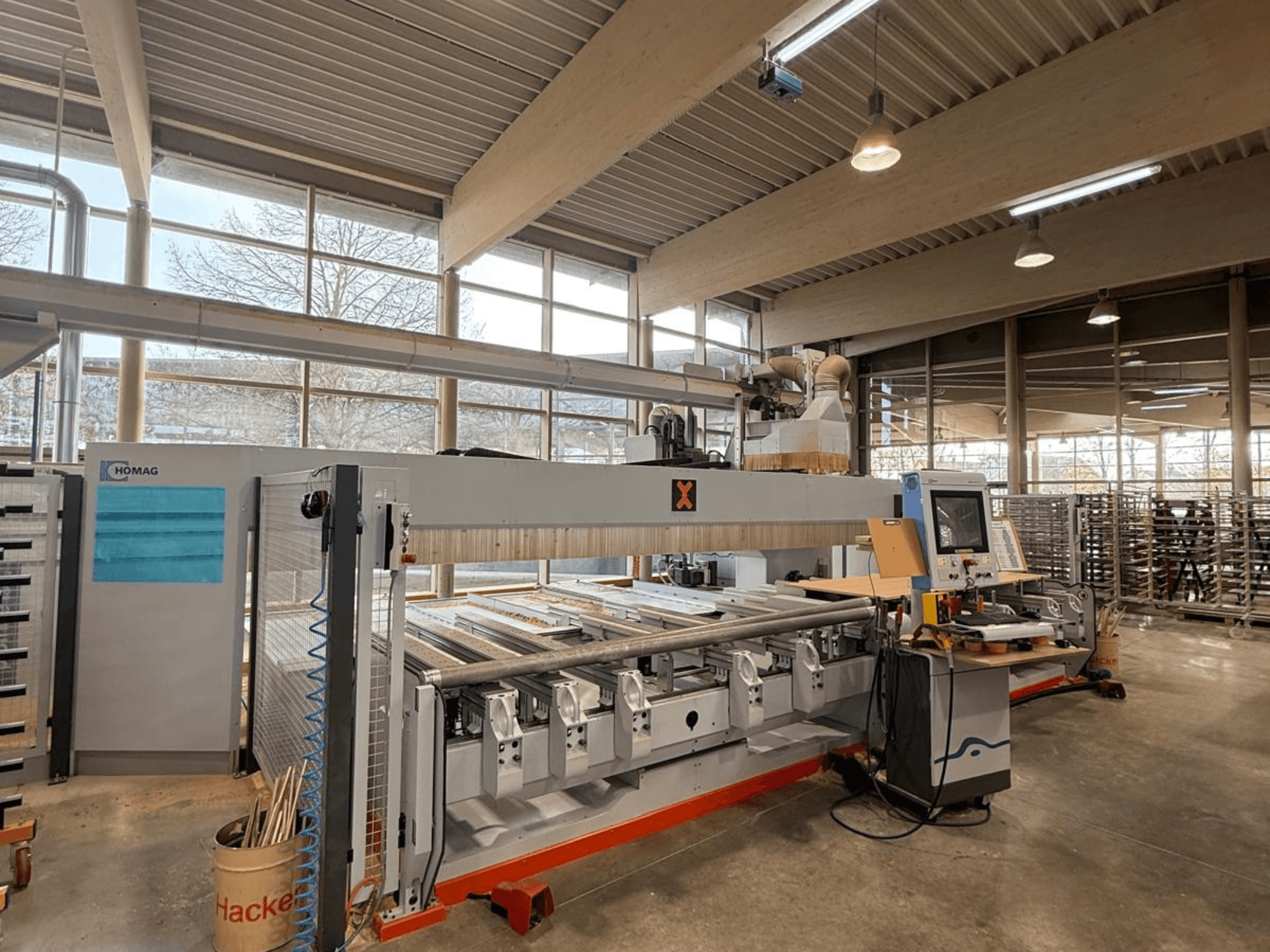 HOMAG CNC-Maschine in einer Werkstatt, Vorderansicht, mit Bedienfeld und mehreren Werkzeugplätzen für die Präzisionsholzbearbeitung.