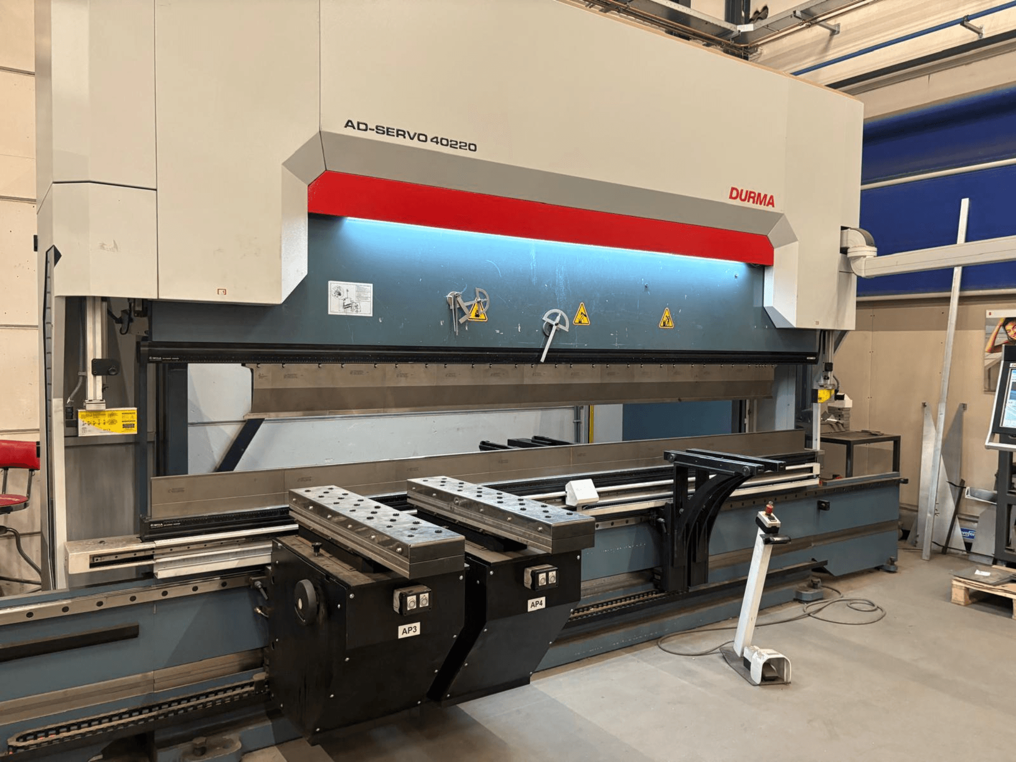 Abkantpresse Durma AD-SERVO 40220, Vorderansicht, mit Blick auf das Bedienfeld, das Hydrauliksystem und die Werkzeuge auf dem Arbeitstisch.