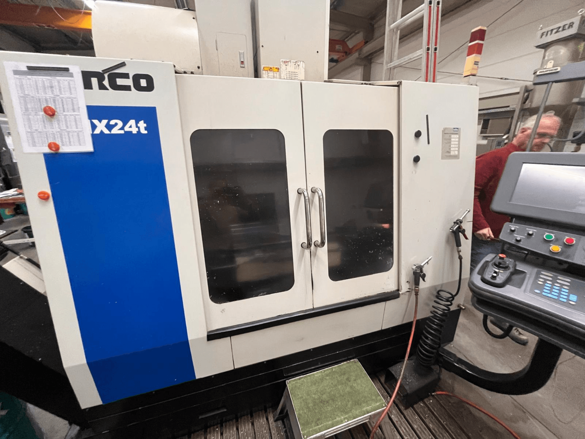 Vertikales Bearbeitungszentrum von Hurco, Modell VX24t, dargestellt von vorne mit Bedienfeld und transparenten Türen.