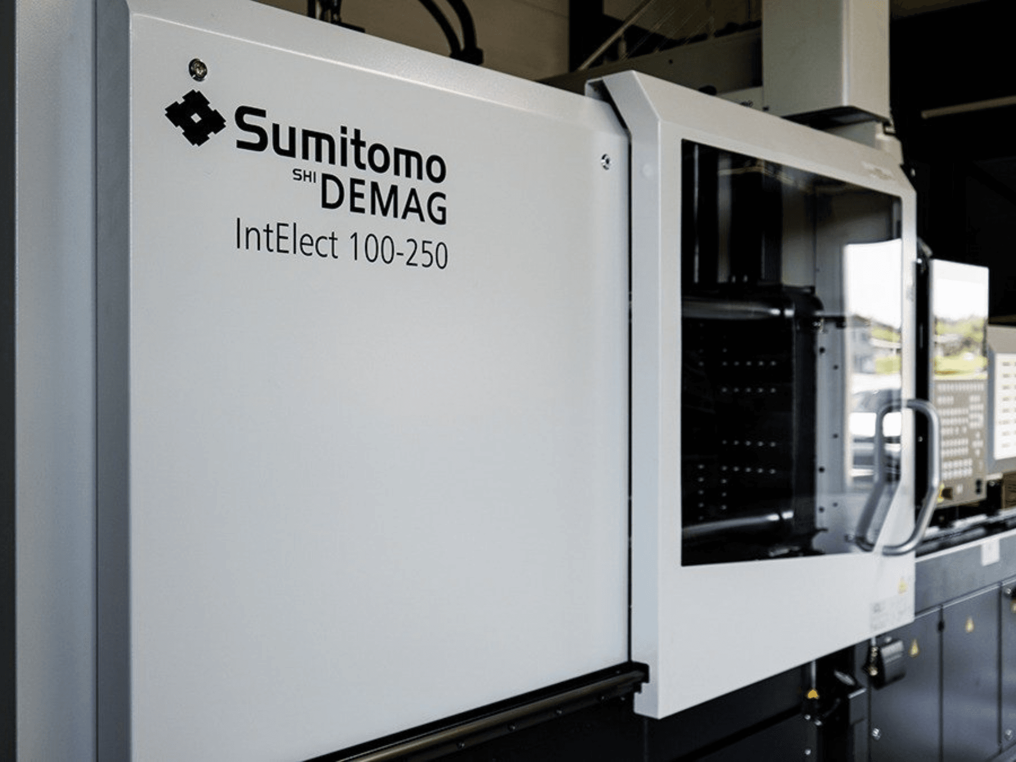 Vorderansicht der elektrischen Spritzgießmaschine SUMITOMO SHI DEMAG IntElect 100/250 mit Bedienfeld und Sicherheitsvorrichtungen.
