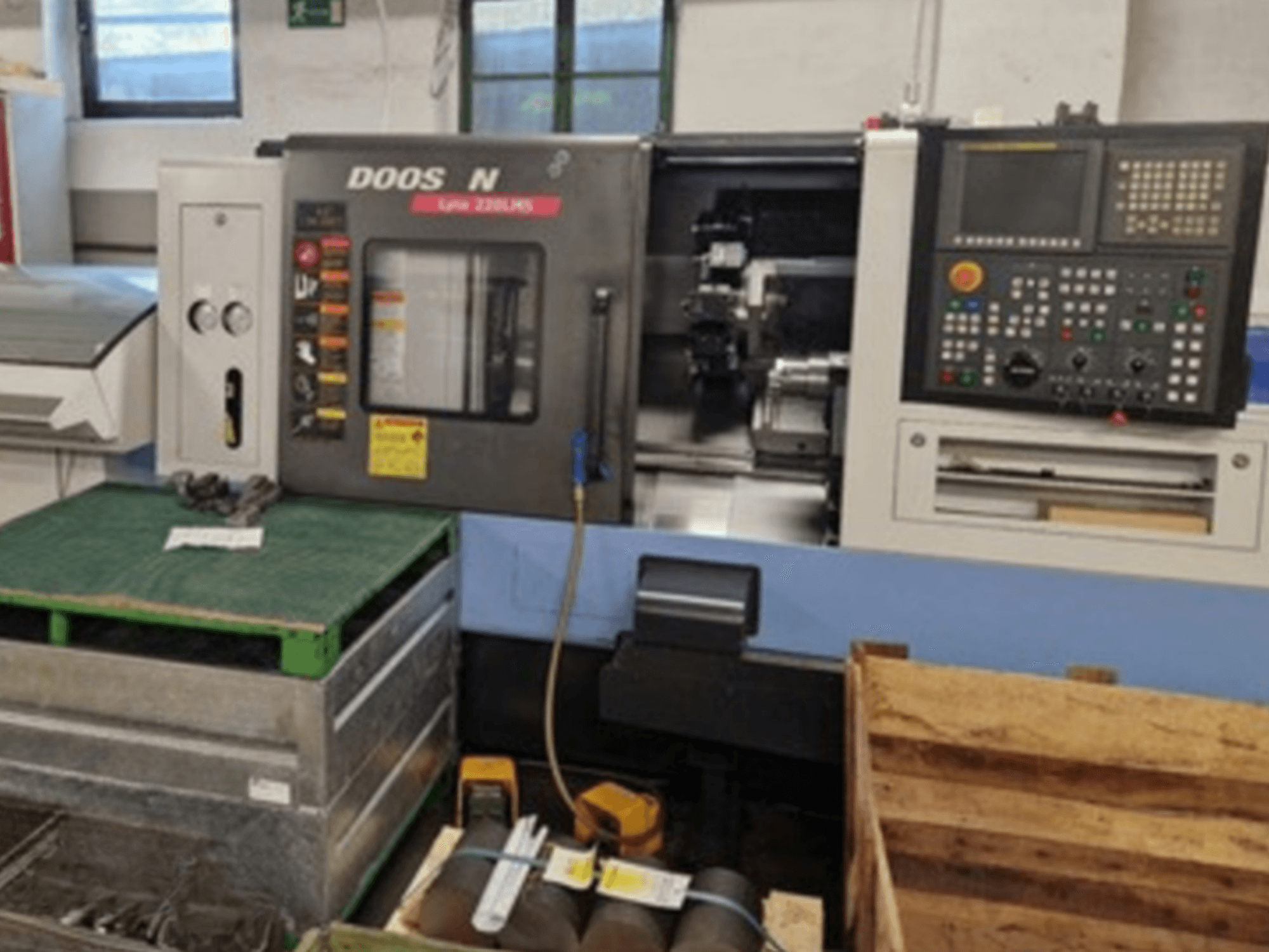 DOOSAN Lyax 220 LMS Horizontal-Drehmaschine in der Vorderansicht, mit Bedienfeld, Werkzeugen und Arbeitsbereich.