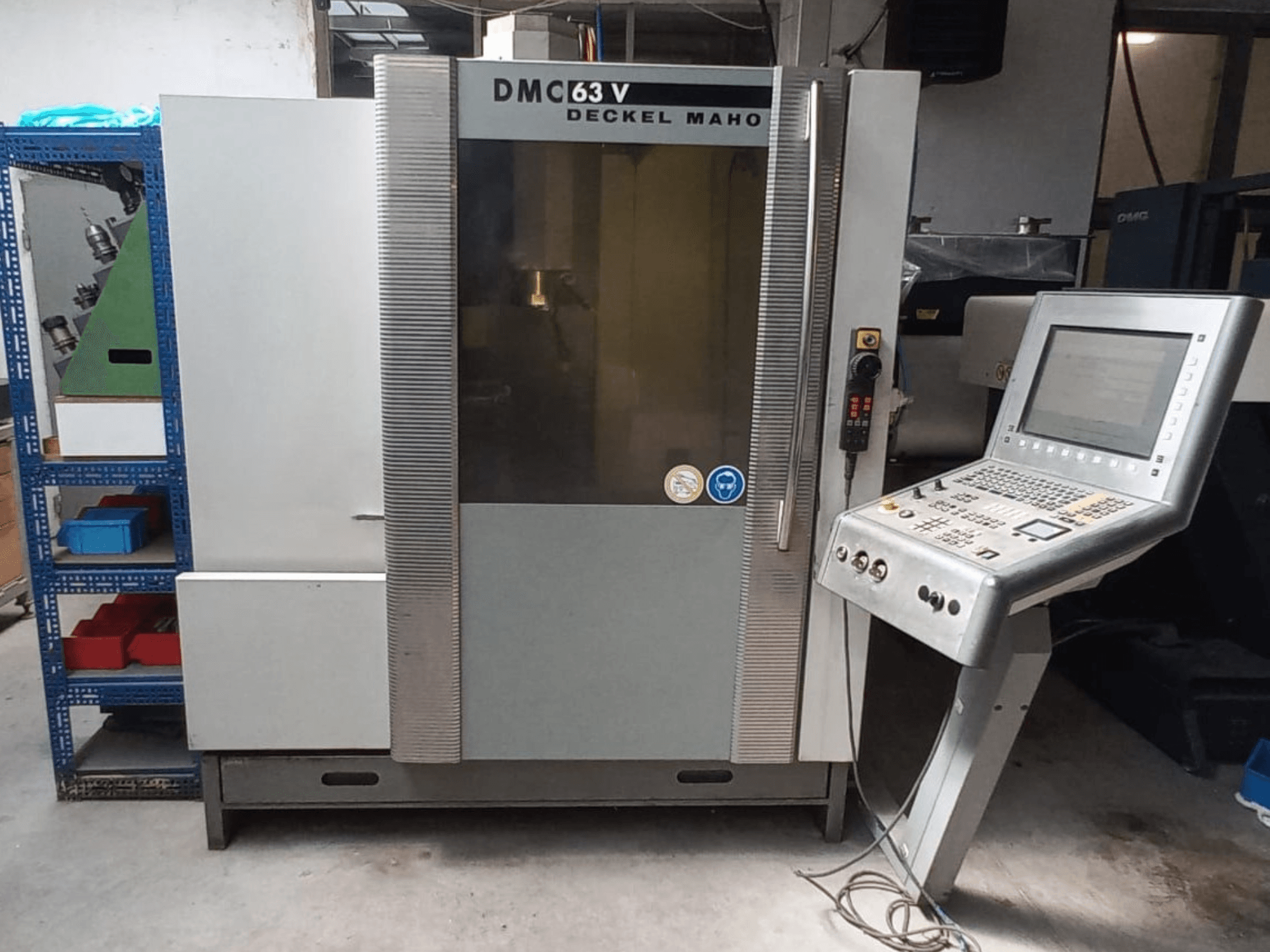 Vorderansicht des vertikalen Bearbeitungszentrums DMG DECKEL MAHO DMC 63V mit Bedienfeld und sichtbarem Arbeitsbereich.